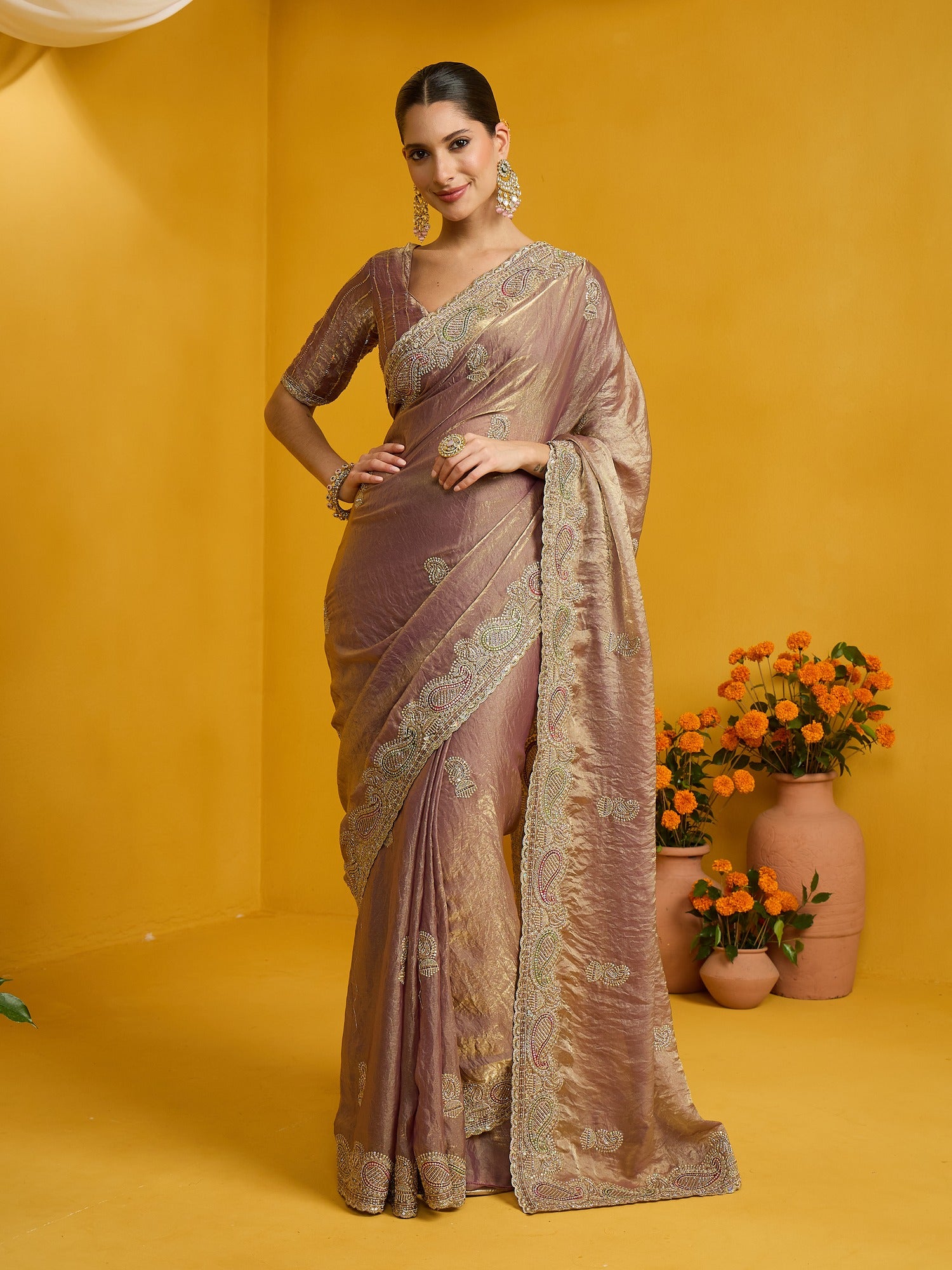 Woman wearing rose gold satin silk saree with zari butta (metallic motif) work and rose gold blouse