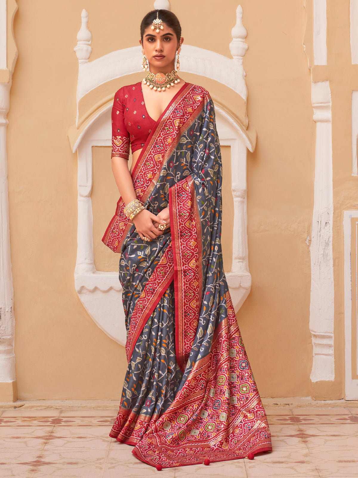 Woman wearing grey silk blend saree with ikat resist-dyed pattern and red blouse