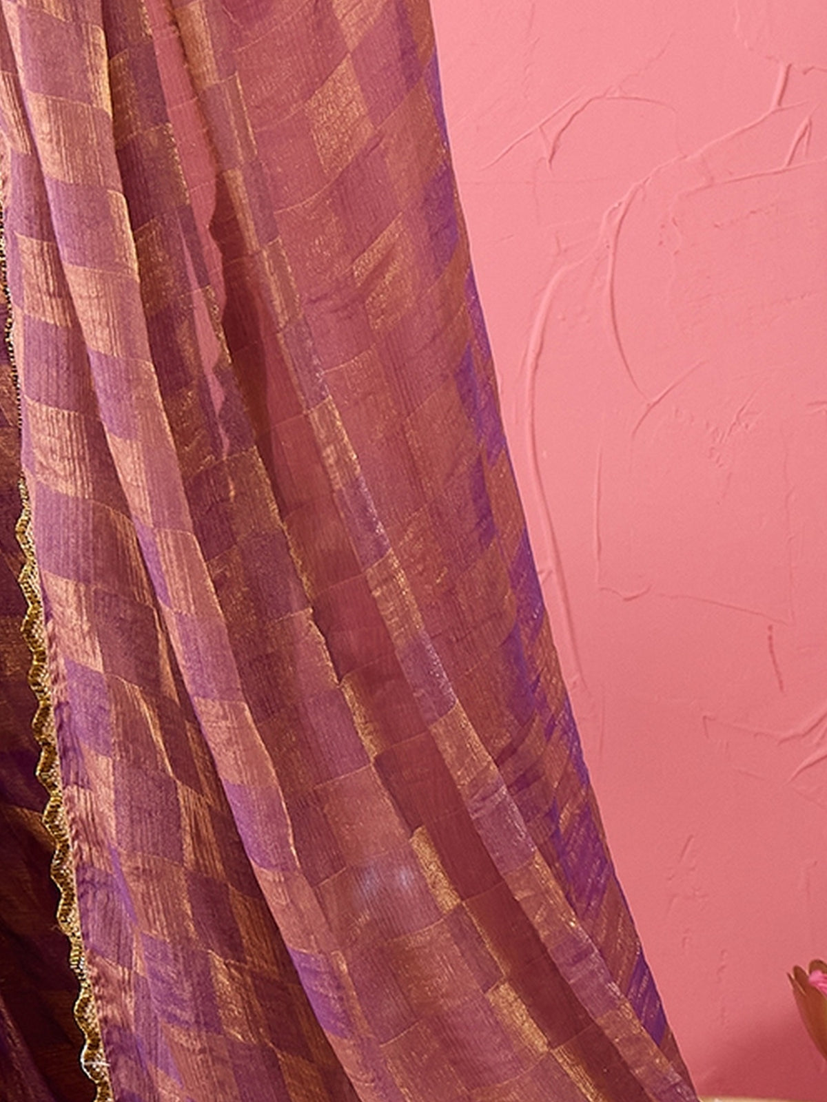 Pallu detail of purple chiffon saree showing checked pattern design and embellished border