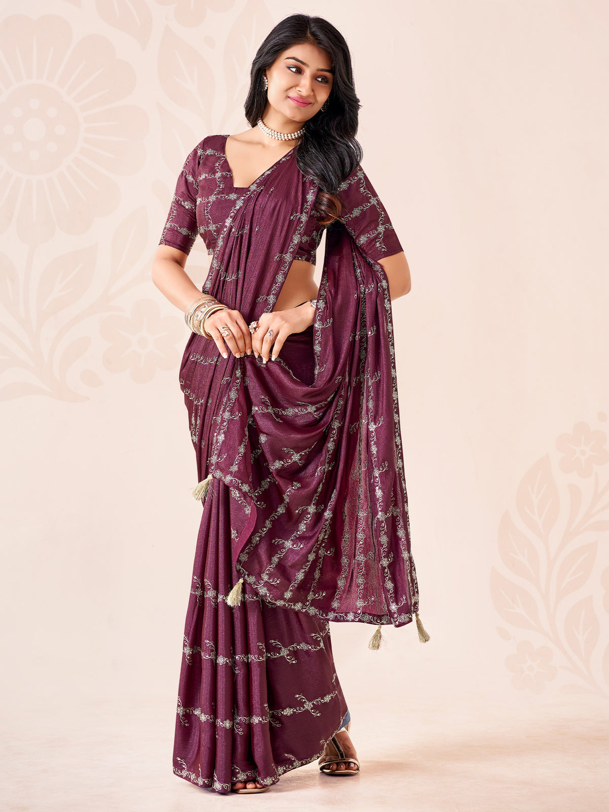 Woman wearing wine chiffon saree with ornamented surface design and wine blouse