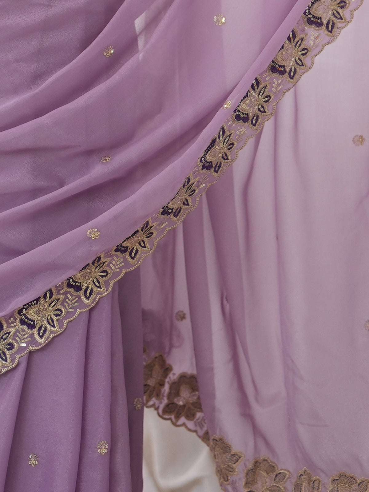 Pallu detail of lavender georgette saree showing ornamented surface design and embellished border