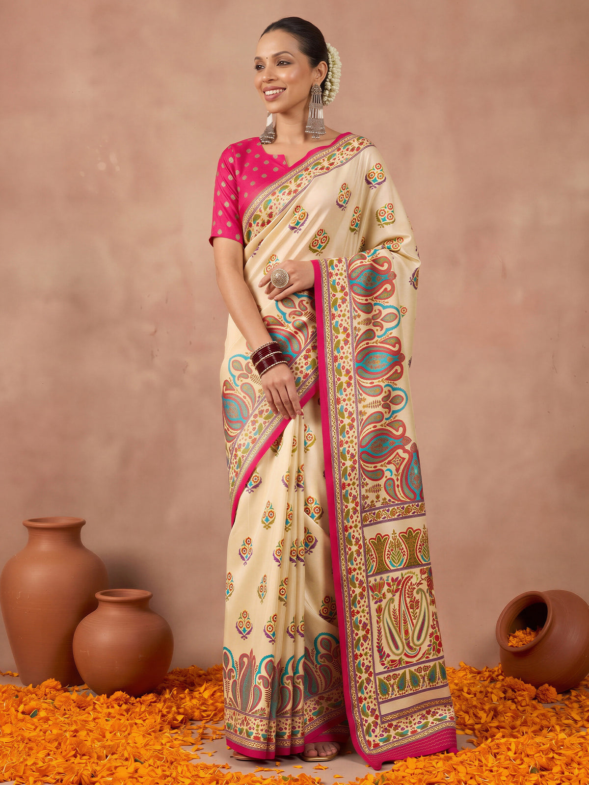 Woman wearing off white silk blend saree with metallic foil print work and pink blouse