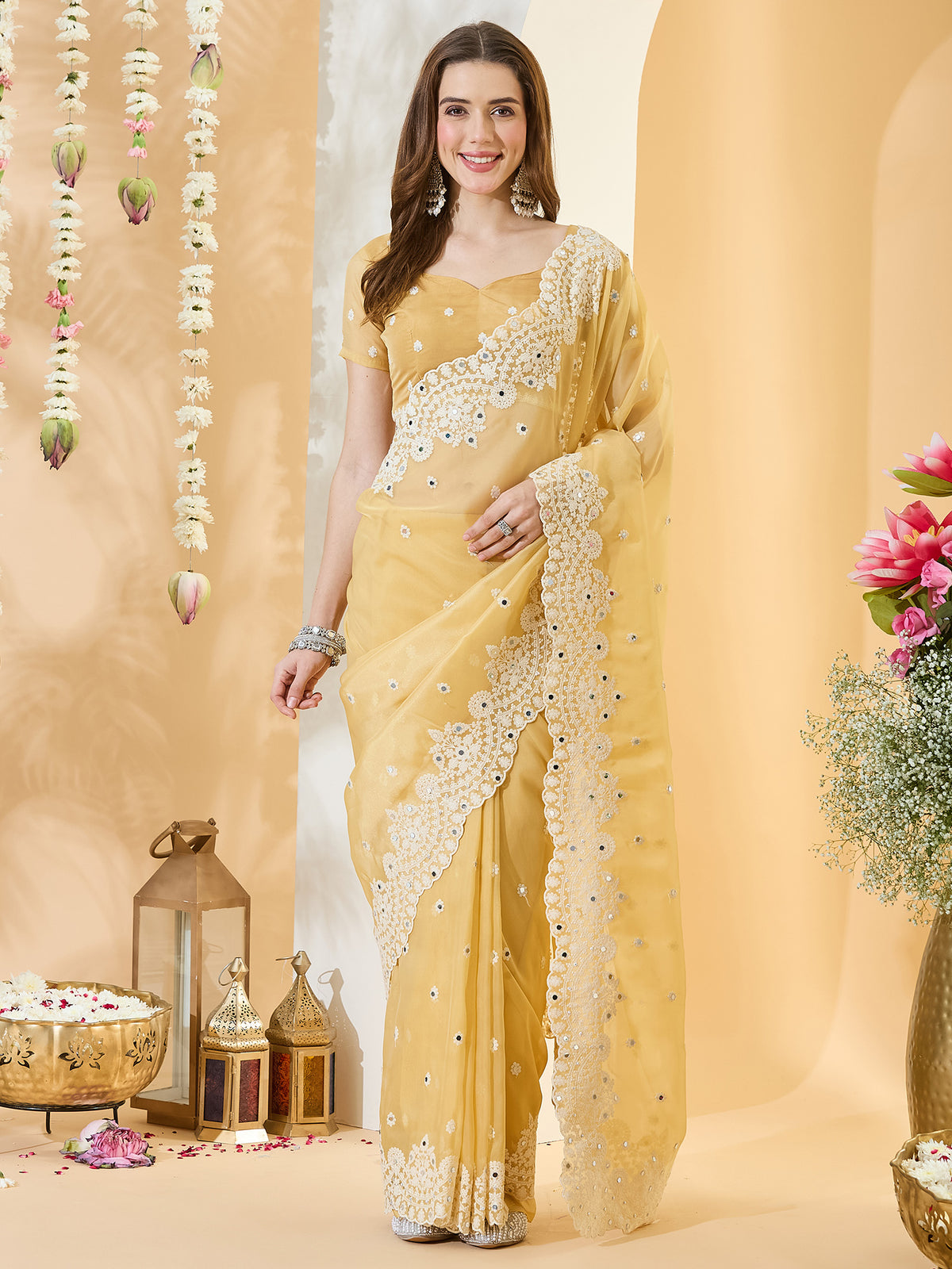 Woman wearing yellow organza saree with embroidered motif work and yellow blouse