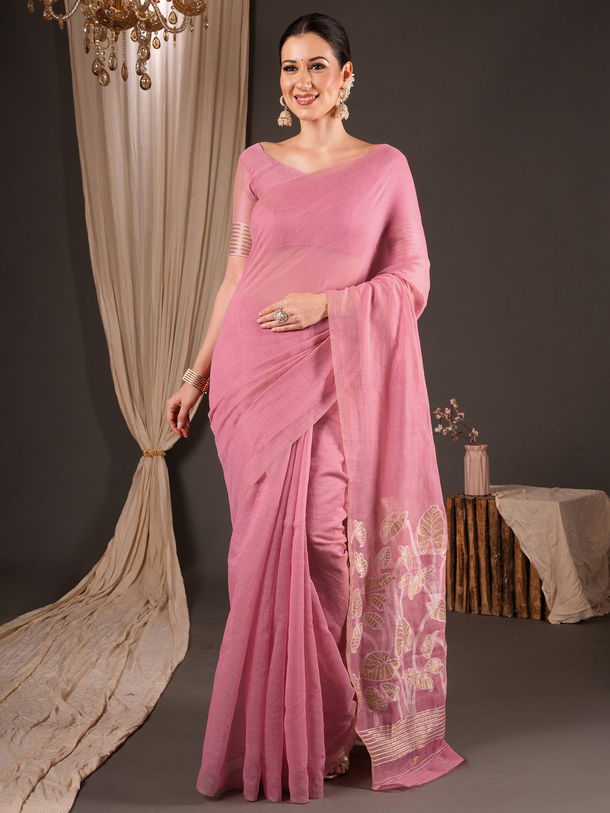Woman wearing pink soft silk saree with clean solid-tone finish and pink blouse