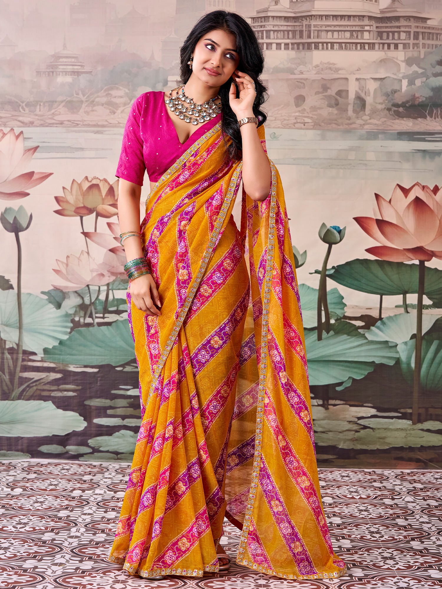 Woman wearing mustard georgette saree with bandhani tie-dye dot work and pink blouse