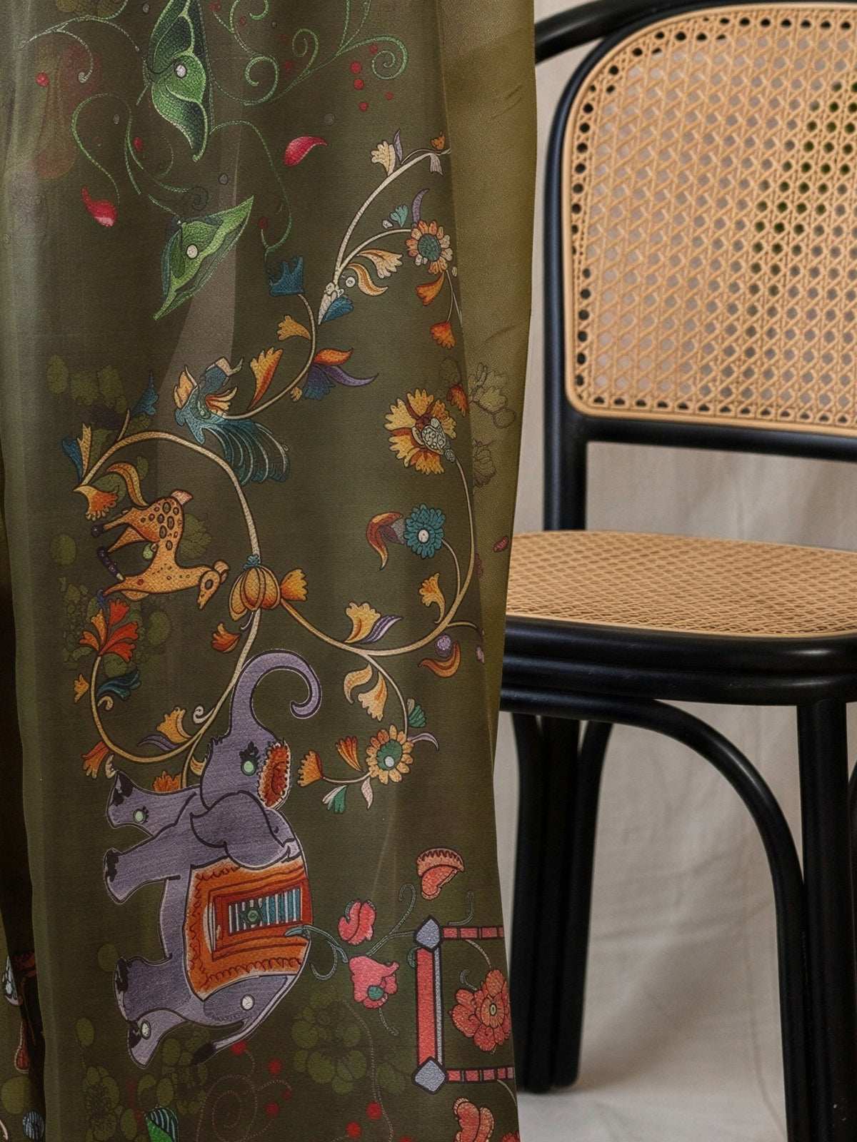 Pallu detail of olive linen blend saree showing traditional indian motif work and printed border