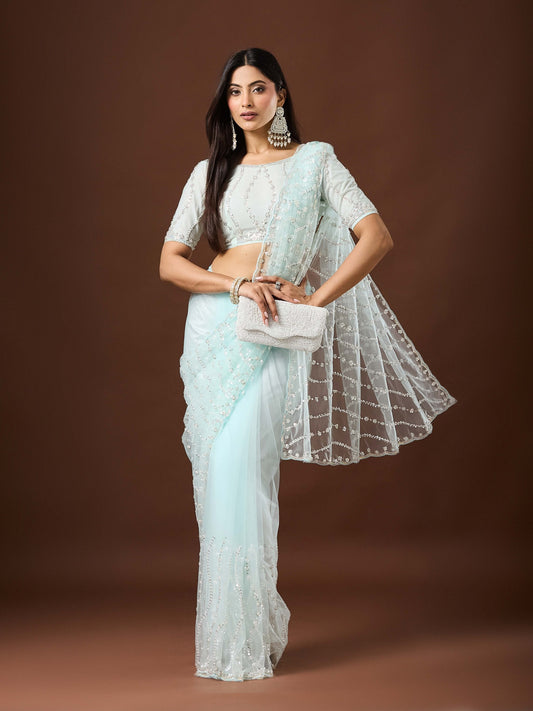 Woman wearing light blue net saree with ornamented surface design and light blue blouse