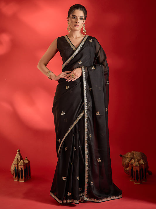 Woman wearing black georgette saree with ornamented surface design and black blouse