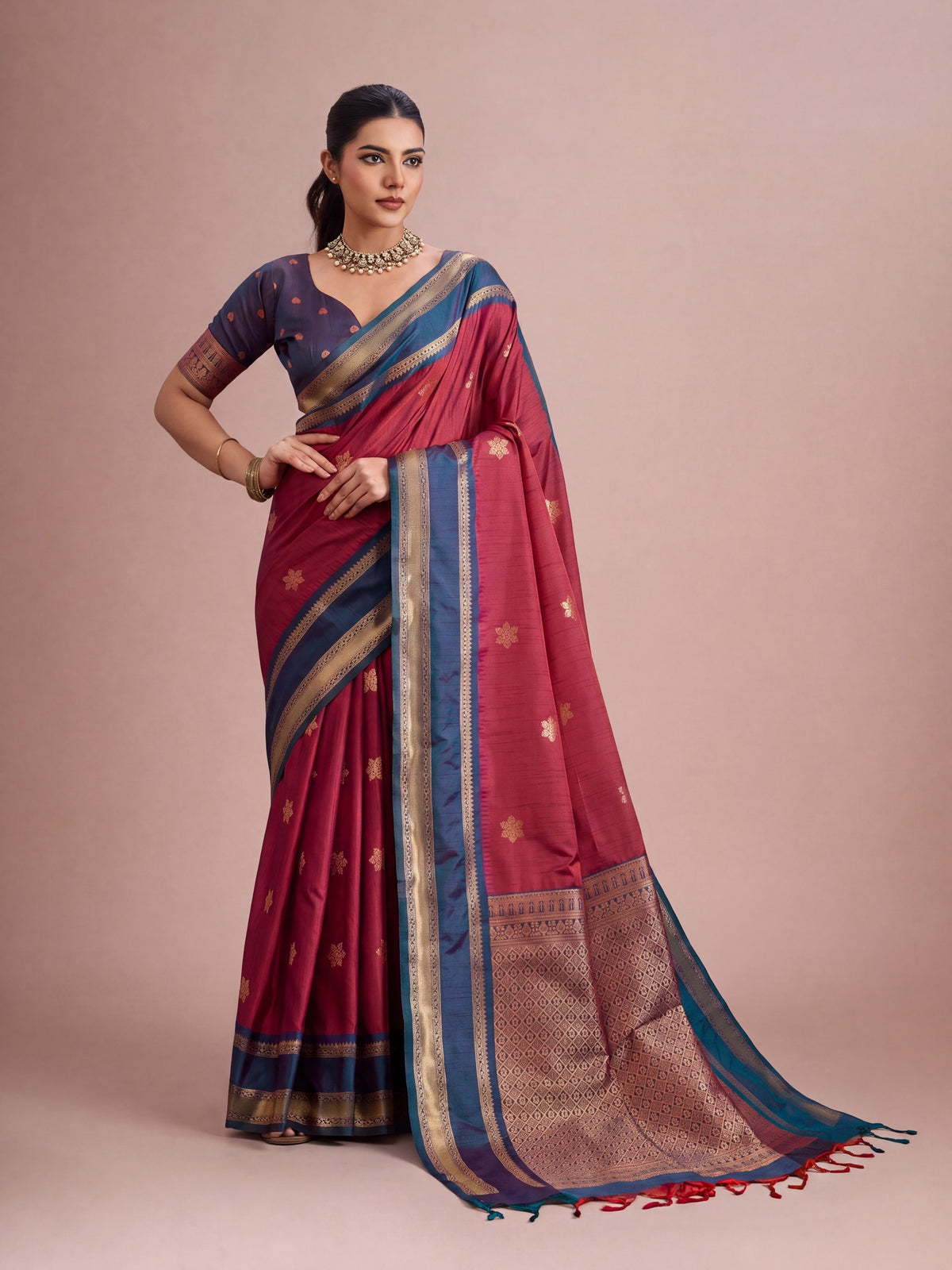 Woman wearing maroon tussar silk saree with traditional indian motif work and blue blouse