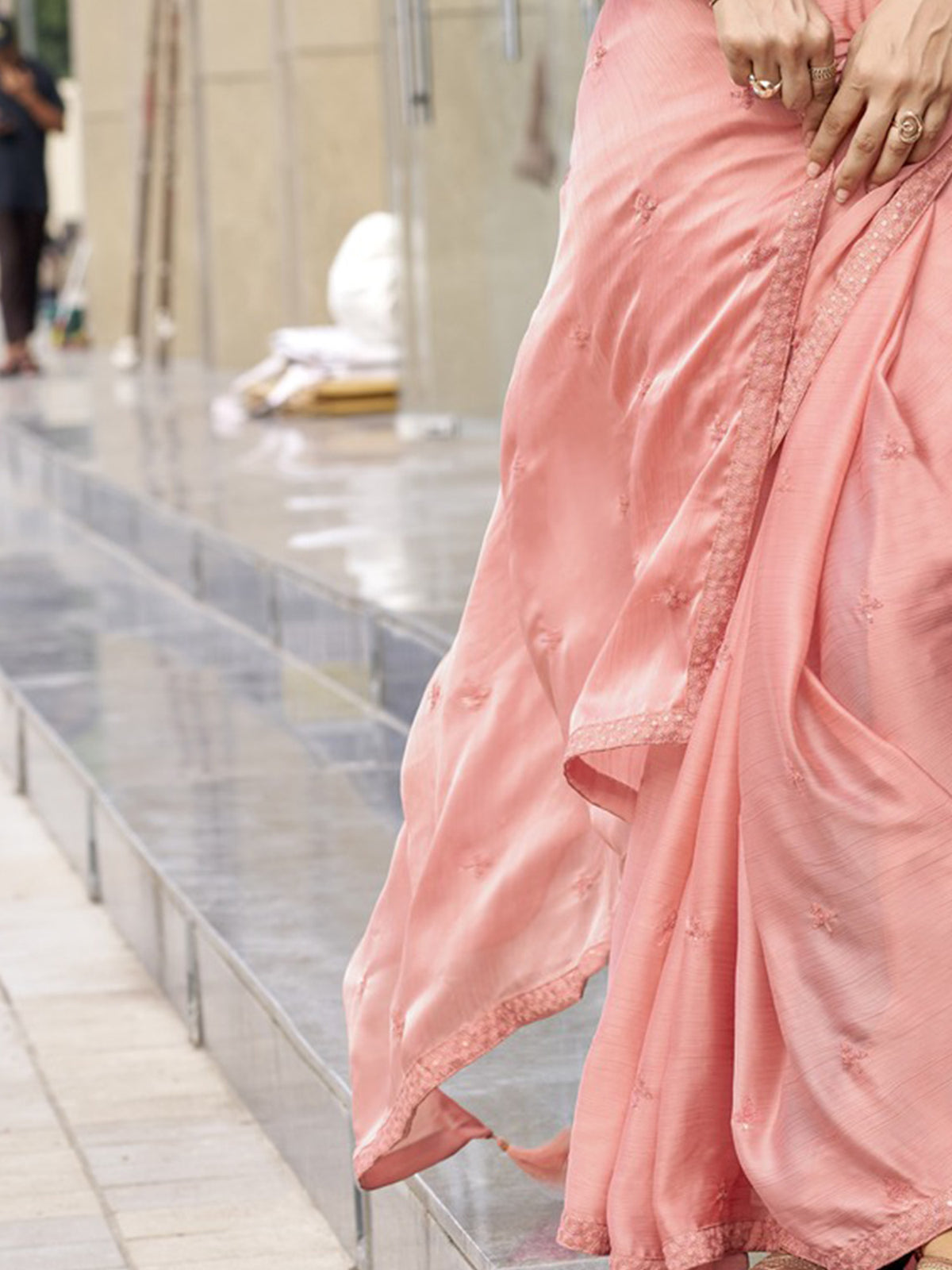 Pallu detail of peach satin silk saree showing ornamented surface design and embellished border