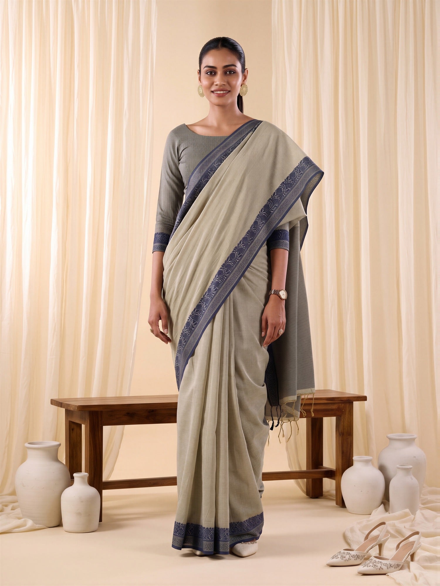 Woman wearing beige cotton blend saree with traditional indian motif work and blue blouse