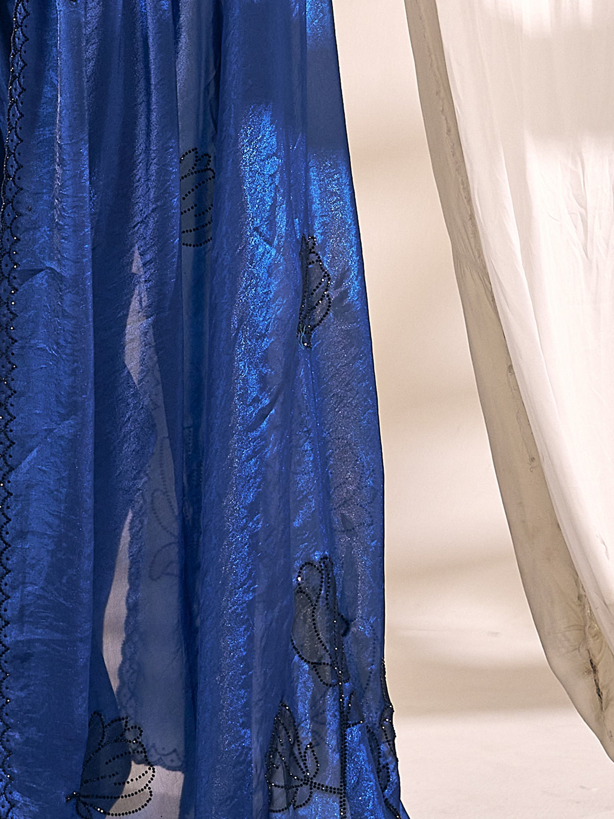 Pallu detail of blue satin silk saree showing ornamented surface design and scallop border