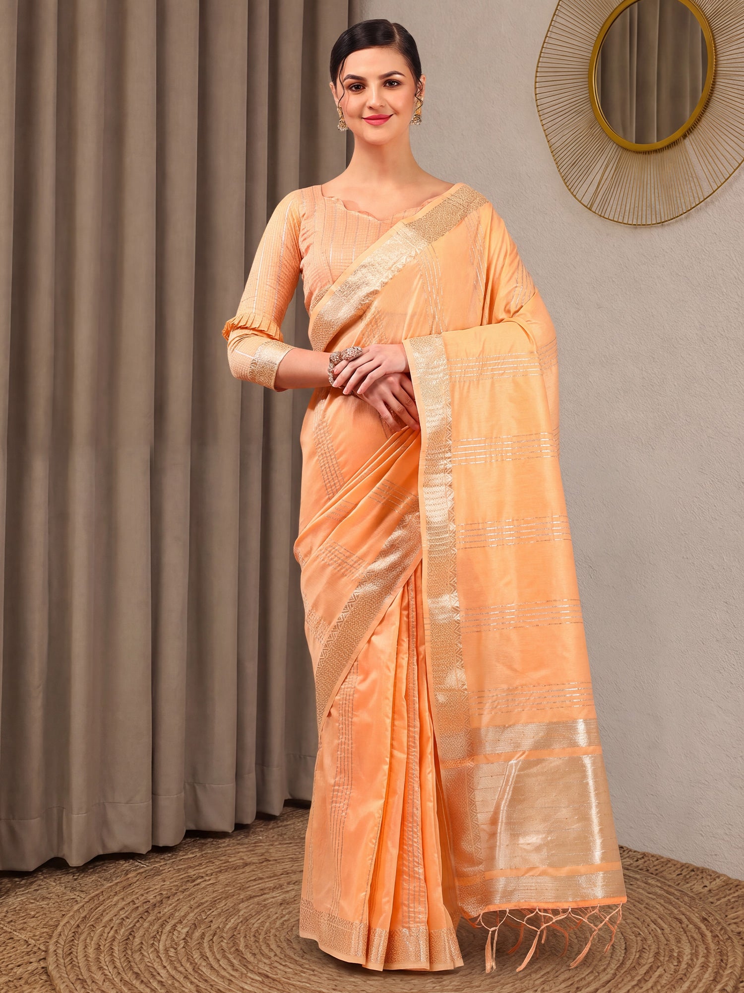 Woman wearing peach linen saree with zari butta (metallic motif) work and peach blouse