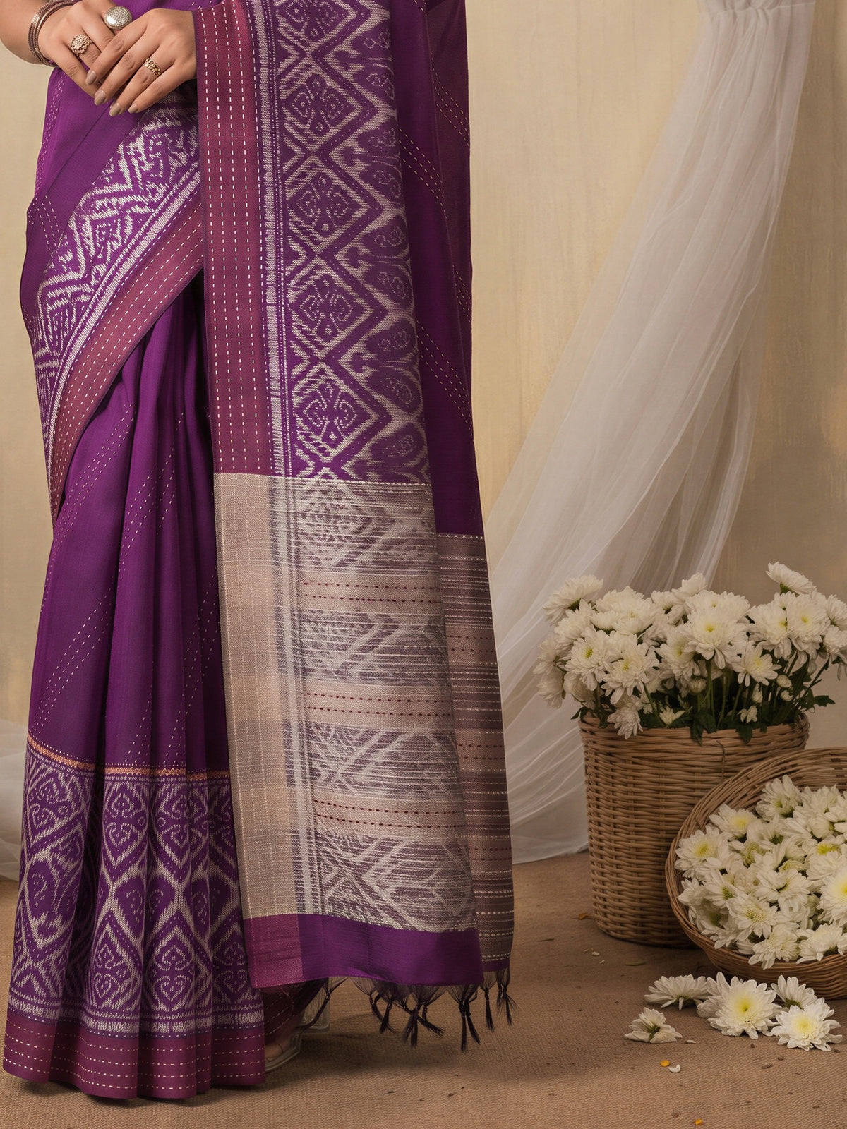 Pallu detail of magenta silk cotton saree showing ikat resist-dyed pattern and embroidered border