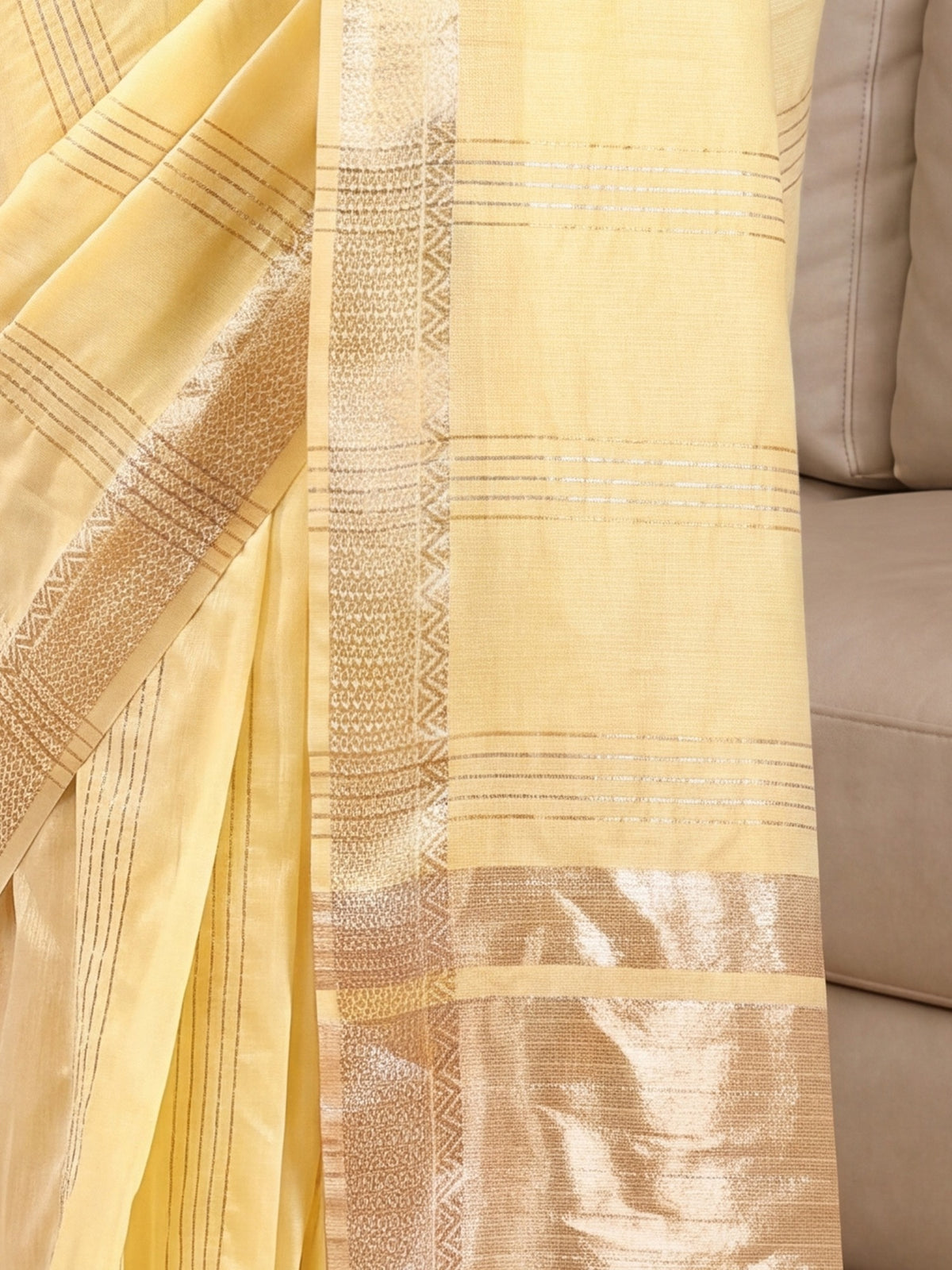 Pallu detail of yellow linen saree showing zari butta (metallic motif) work and zari border
