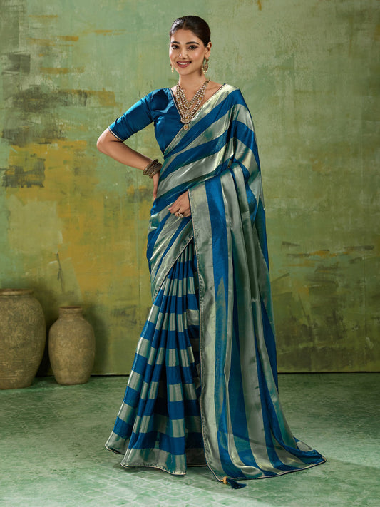 Woman wearing teal blue satin silk saree with colour-blocked design and teal blue blouse