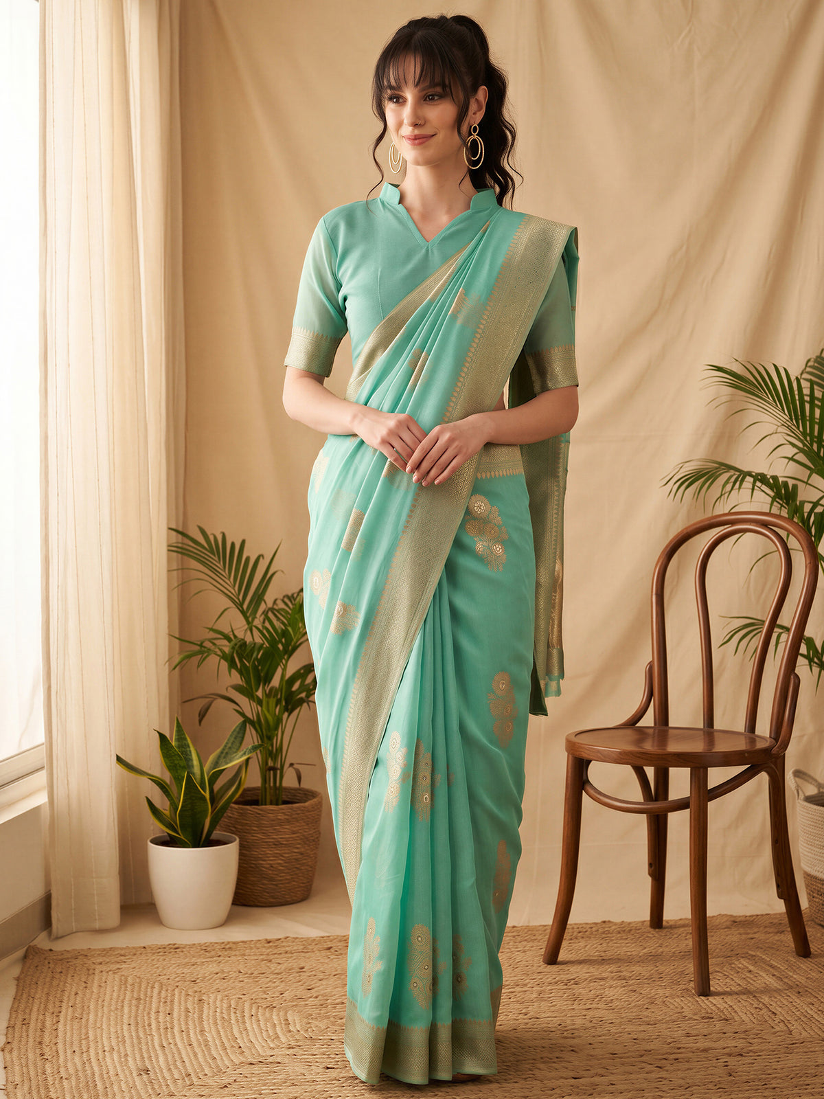 Woman wearing teal green silk blend saree with all-over floral design and teal green blouse