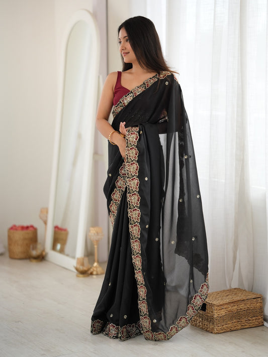 Woman wearing black georgette saree with ornamented surface design and maroon blouse