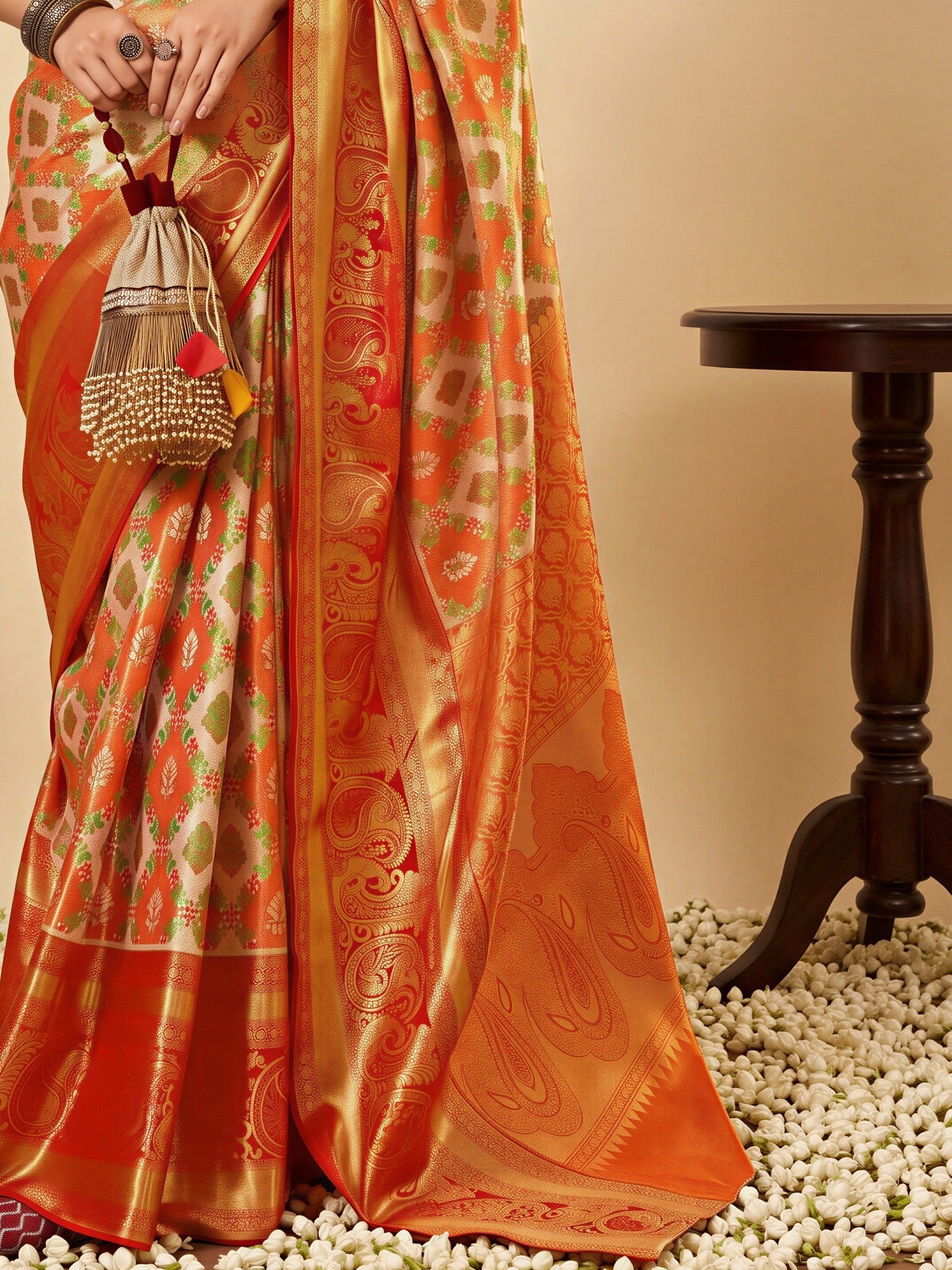 Pallu detail of orange silk blend saree showing traditional indian motif work and zari border