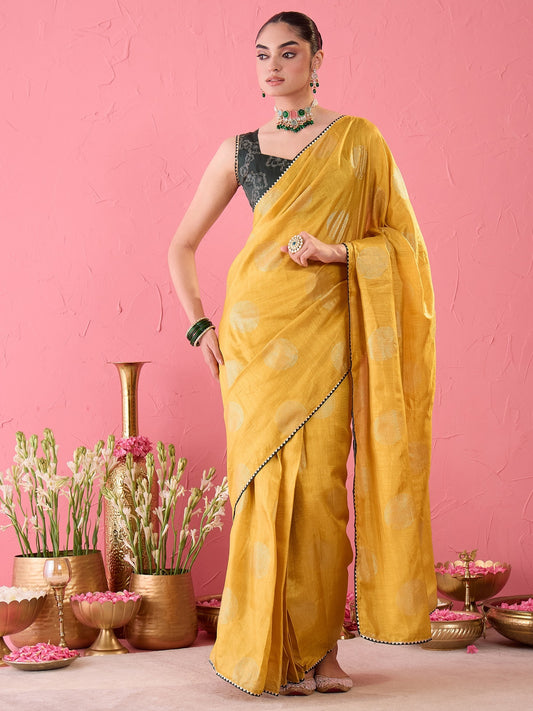 Woman wearing mustard dola silk ready to wear saree with metallic foil print work and green blouse