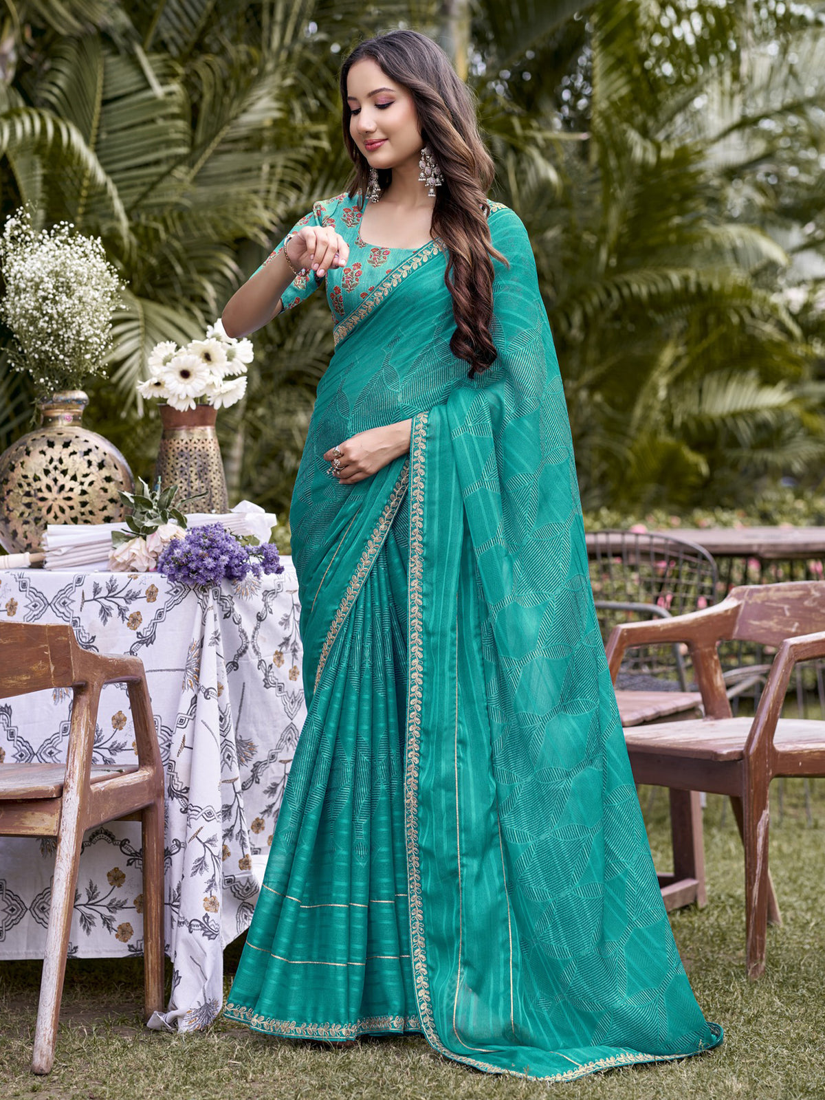 Woman wearing turquoise blue chiffon saree with traditional indian motif work and turquoise blue blouse
