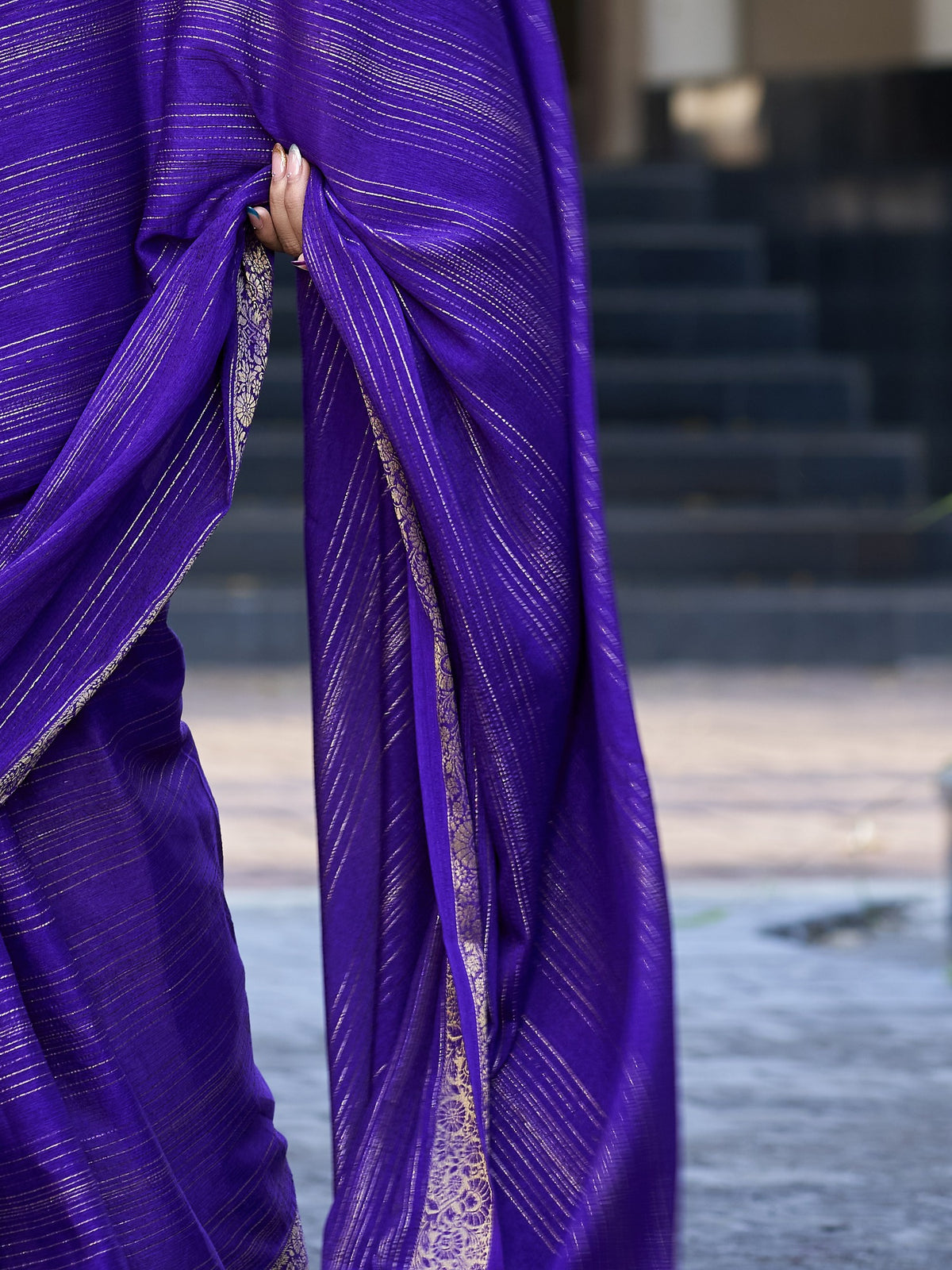 Pallu detail of violet jacquard saree showing striped pattern design and zari border