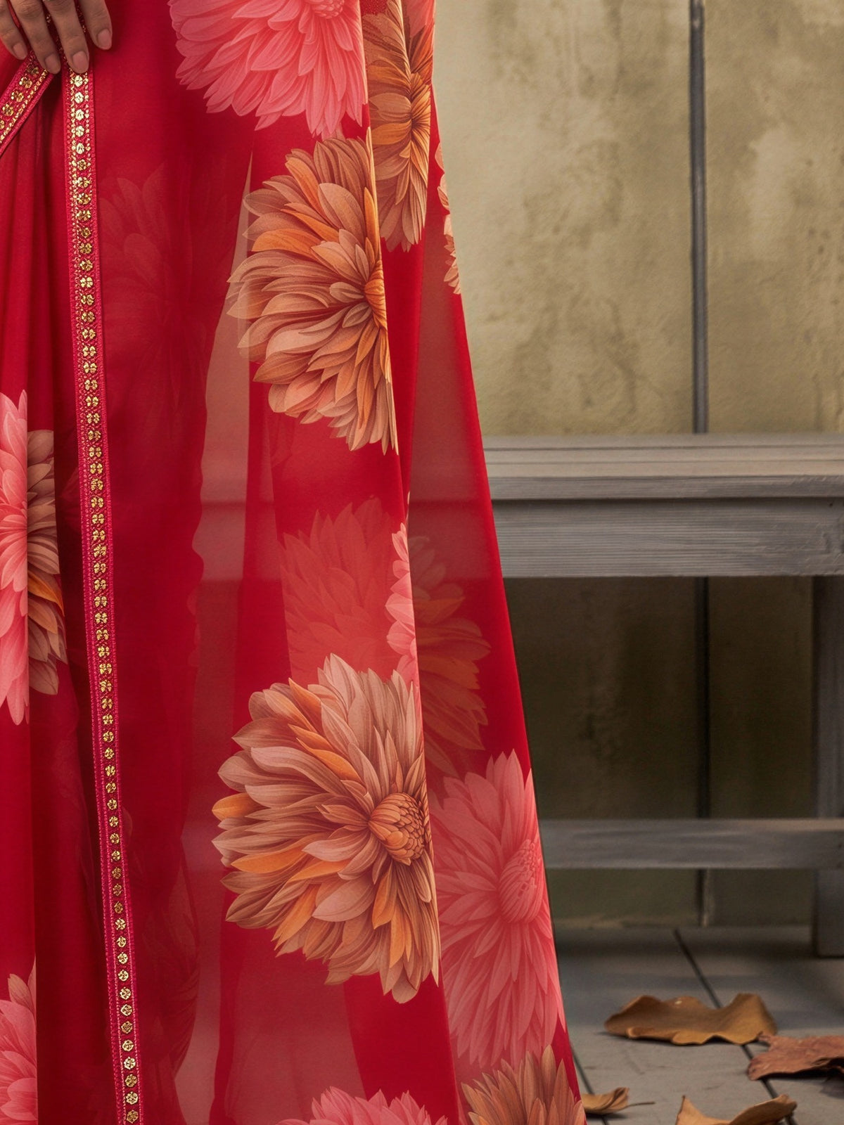 Pallu detail of pink georgette saree showing all-over floral design and embellished border