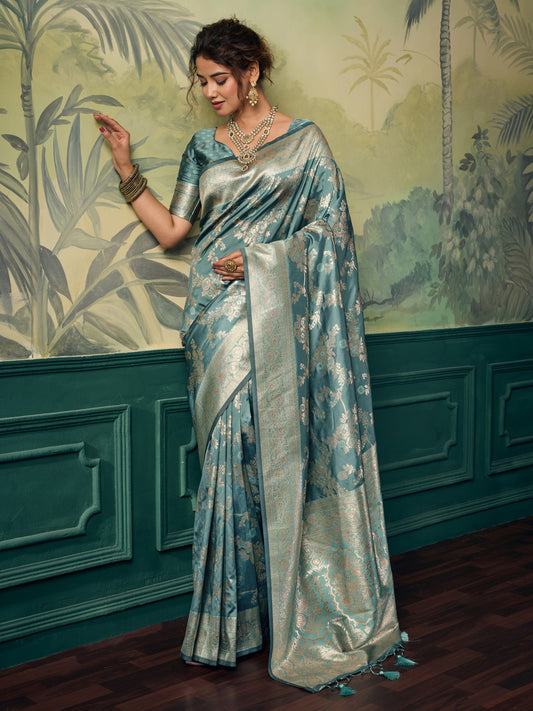 Woman wearing teal blue banarasi silk saree with woven motif design and teal blue blouse