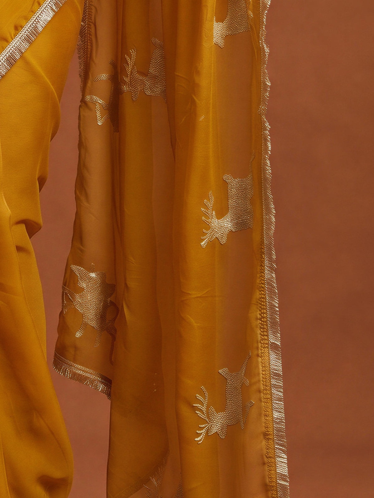 Pallu detail of mustard georgette saree showing embroidered motif work and embellished border