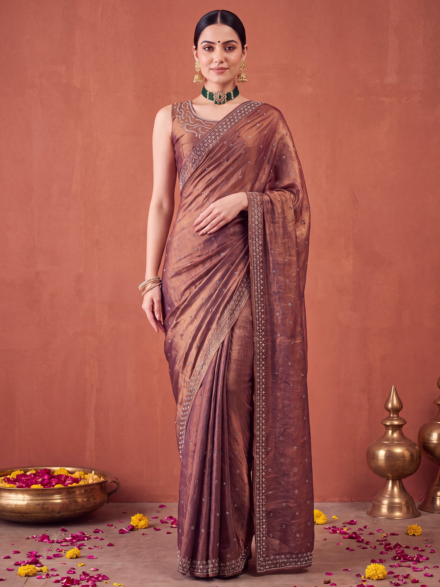 Woman wearing metallic satin silk saree with ornamented surface design and metallic blouse
