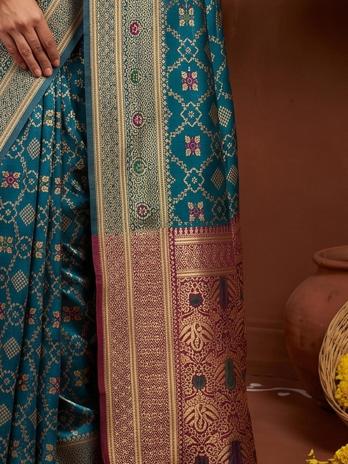 Pallu detail of teal blue silk blend saree showing traditional indian motif work and zari border