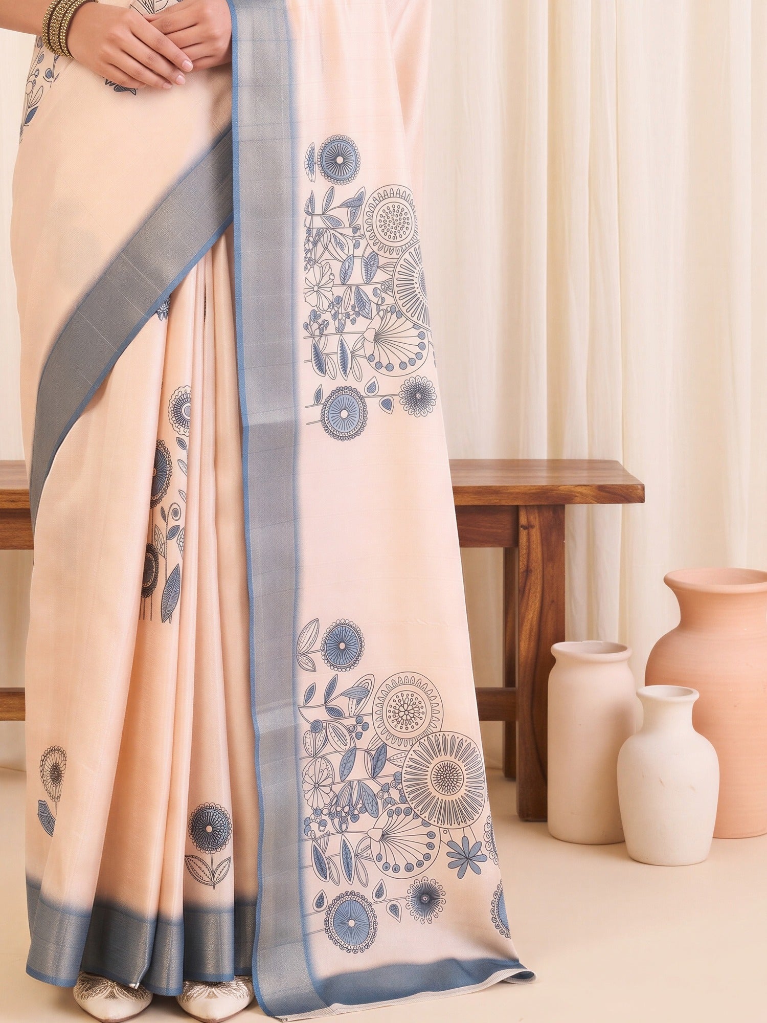 Pallu detail of white satin silk saree showing traditional indian motif work and printed border