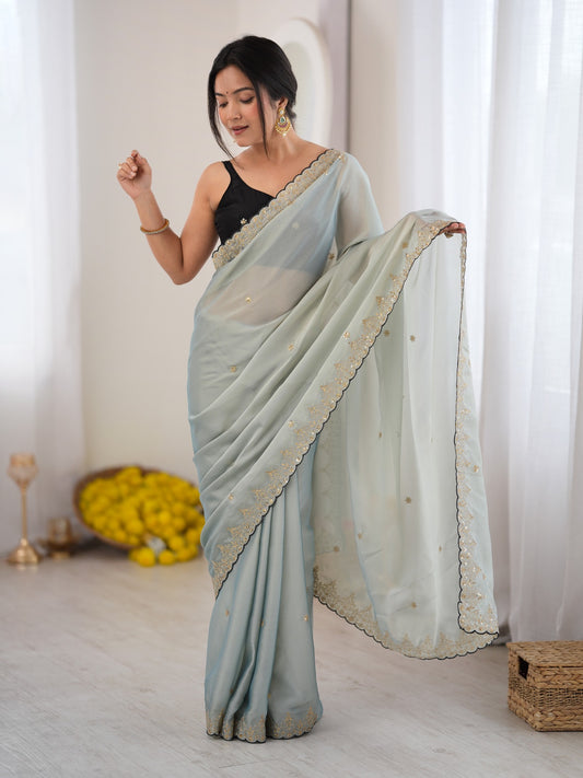 Woman wearing light blue georgette saree with ornamented surface design and black blouse