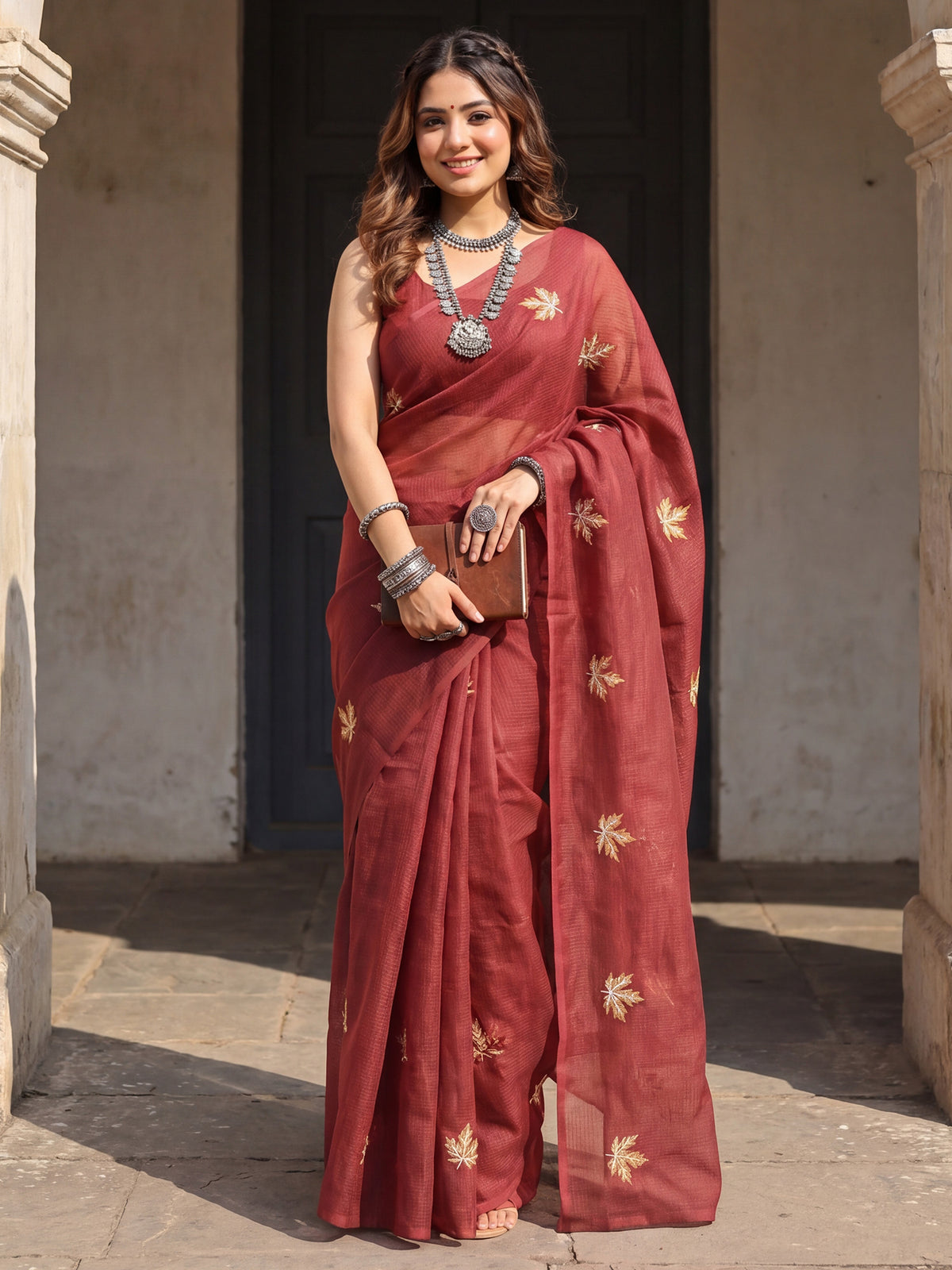Woman wearing maroon kota doria cotton saree with embroidered motif work and maroon blouse