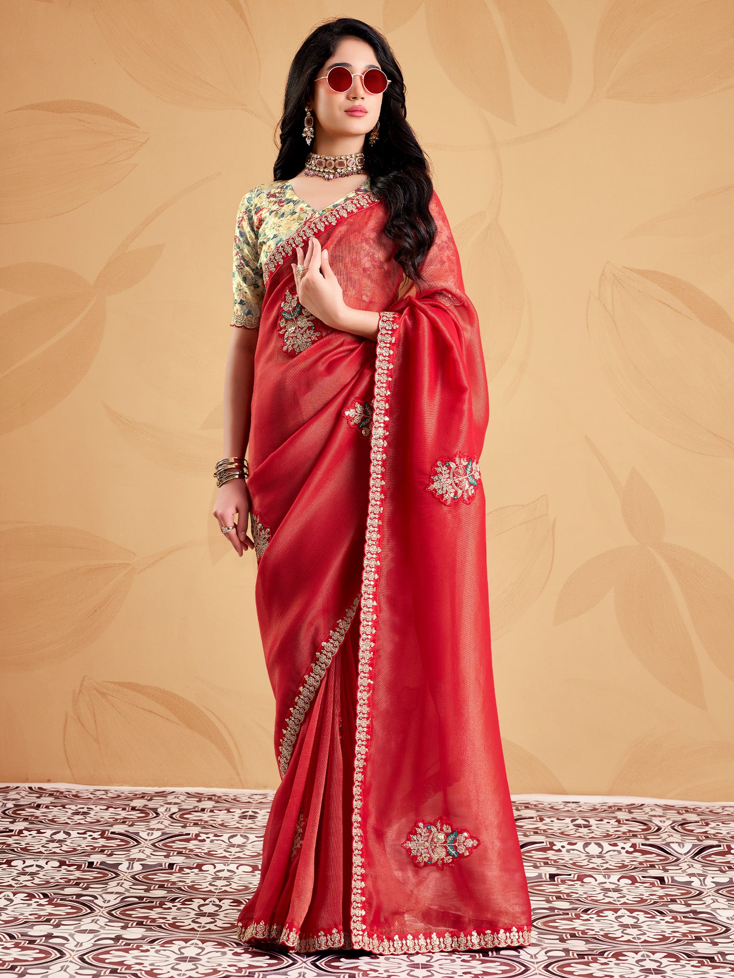 Woman wearing rust tissue saree with ornamented surface design and light green blouse