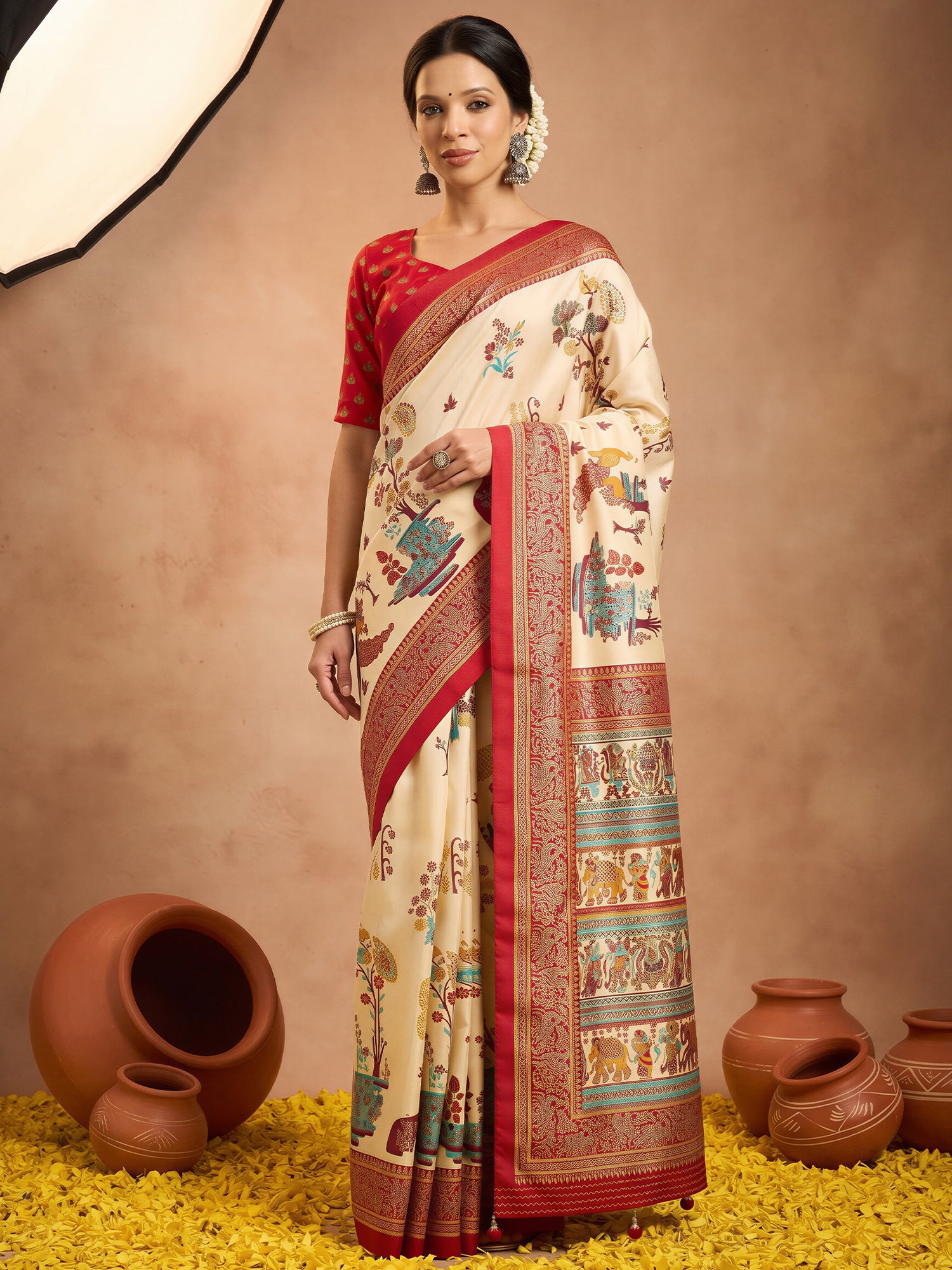 Woman wearing cream silk blend saree with metallic foil print work and red blouse
