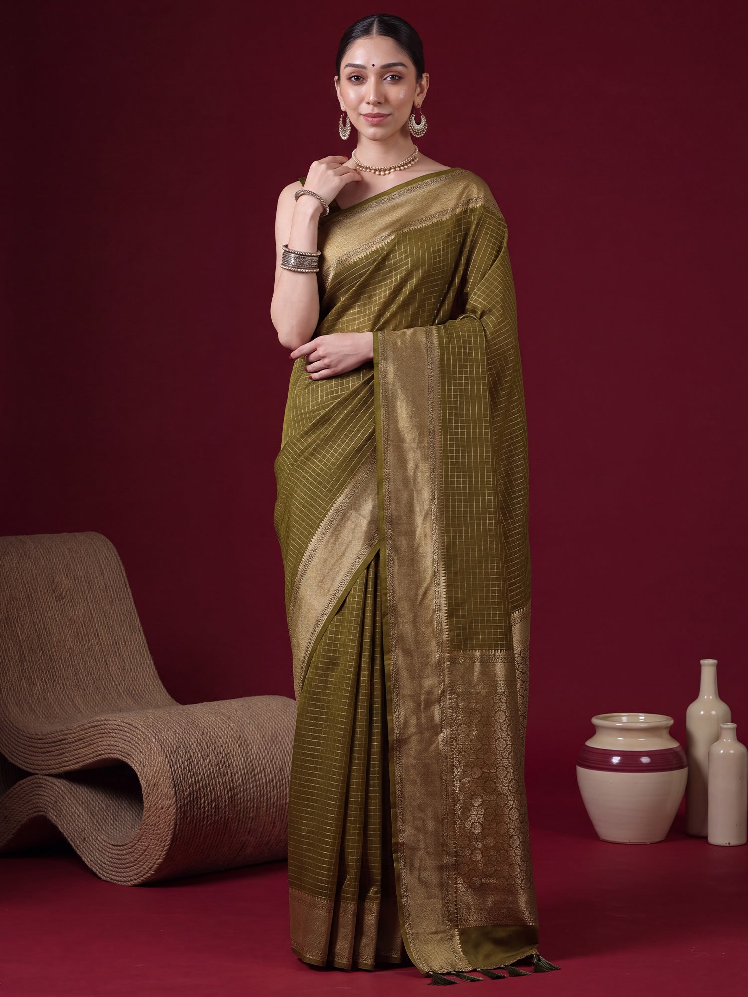 Woman wearing olive banarasi silk saree with checkered design and olive blouse