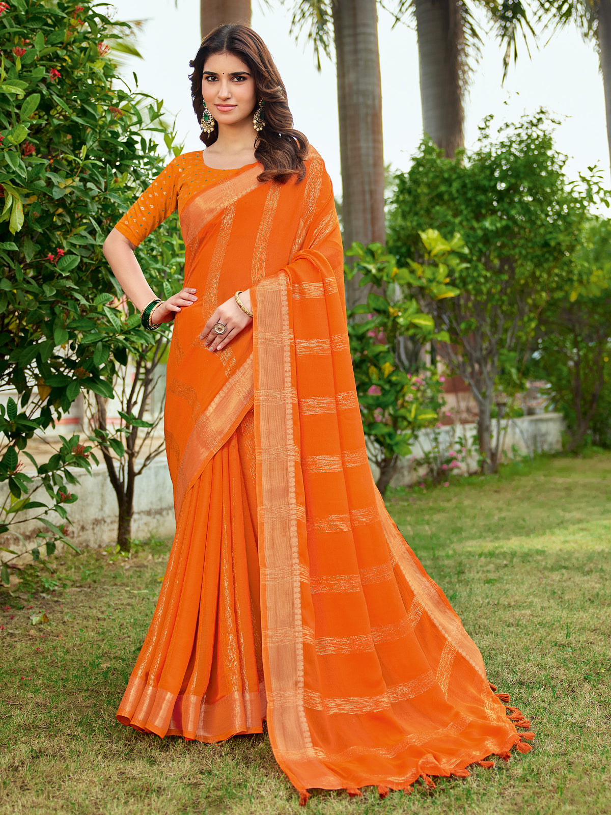 Woman wearing orange georgette saree with striped pattern design and orange blouse