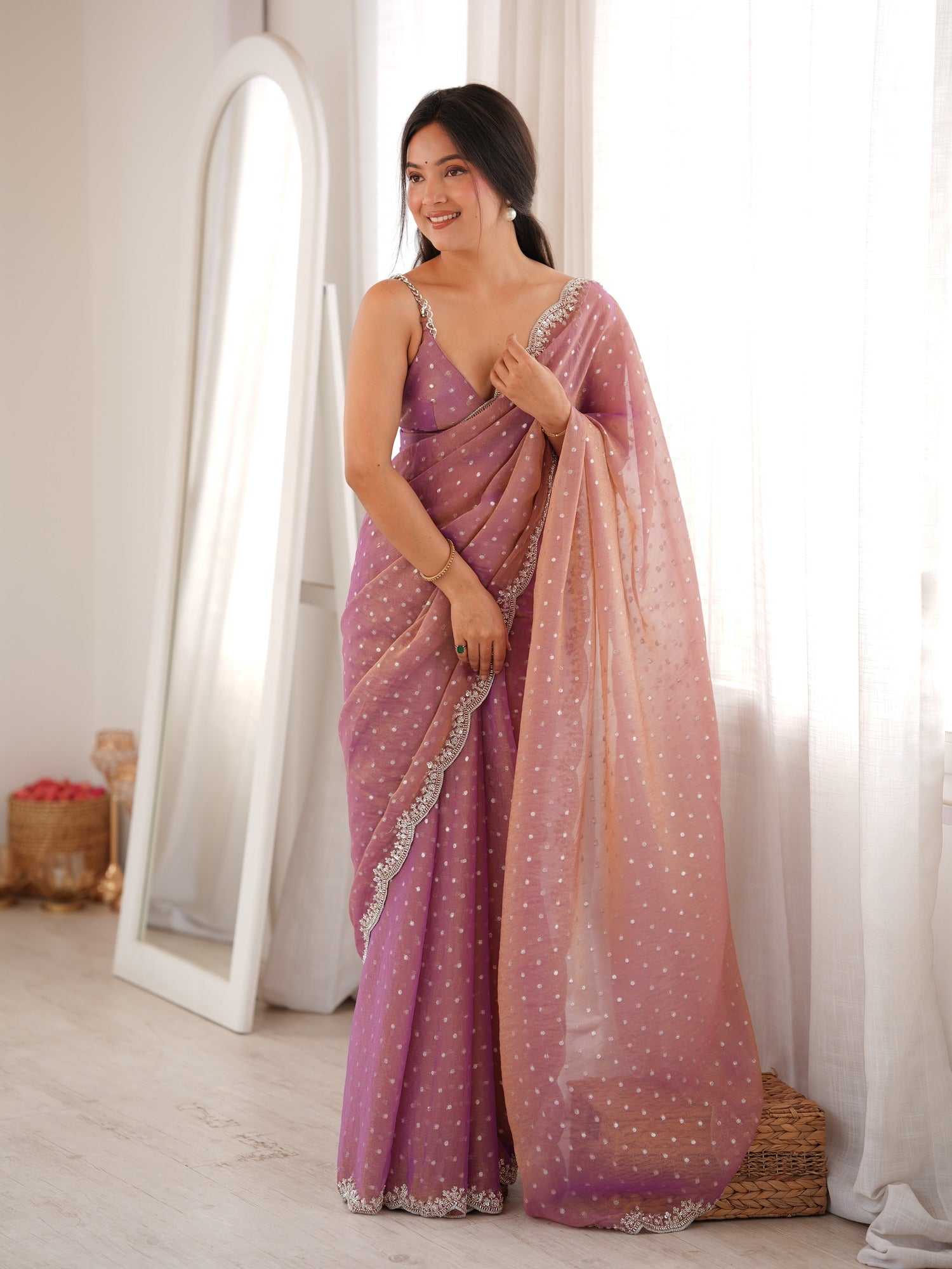 Woman wearing mauve silk blend saree with ornamented surface design and mauve blouse