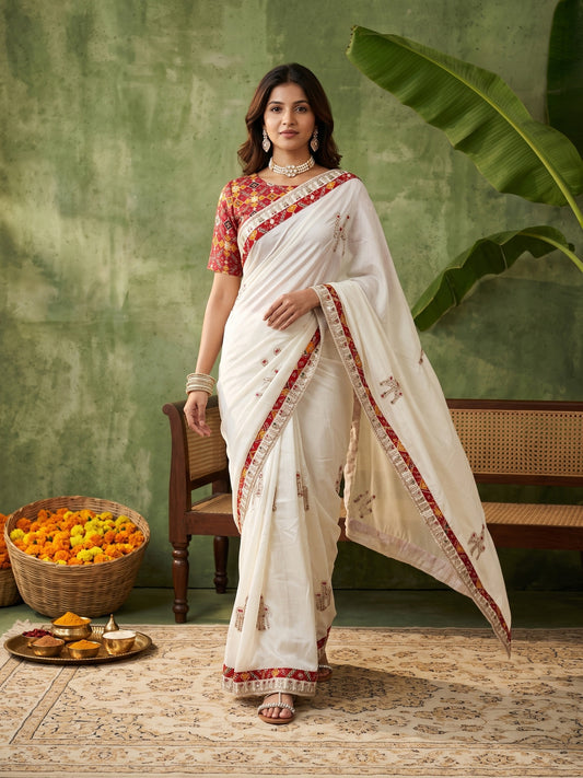 Woman wearing white dola silk saree with ornamented surface design and red blouse
