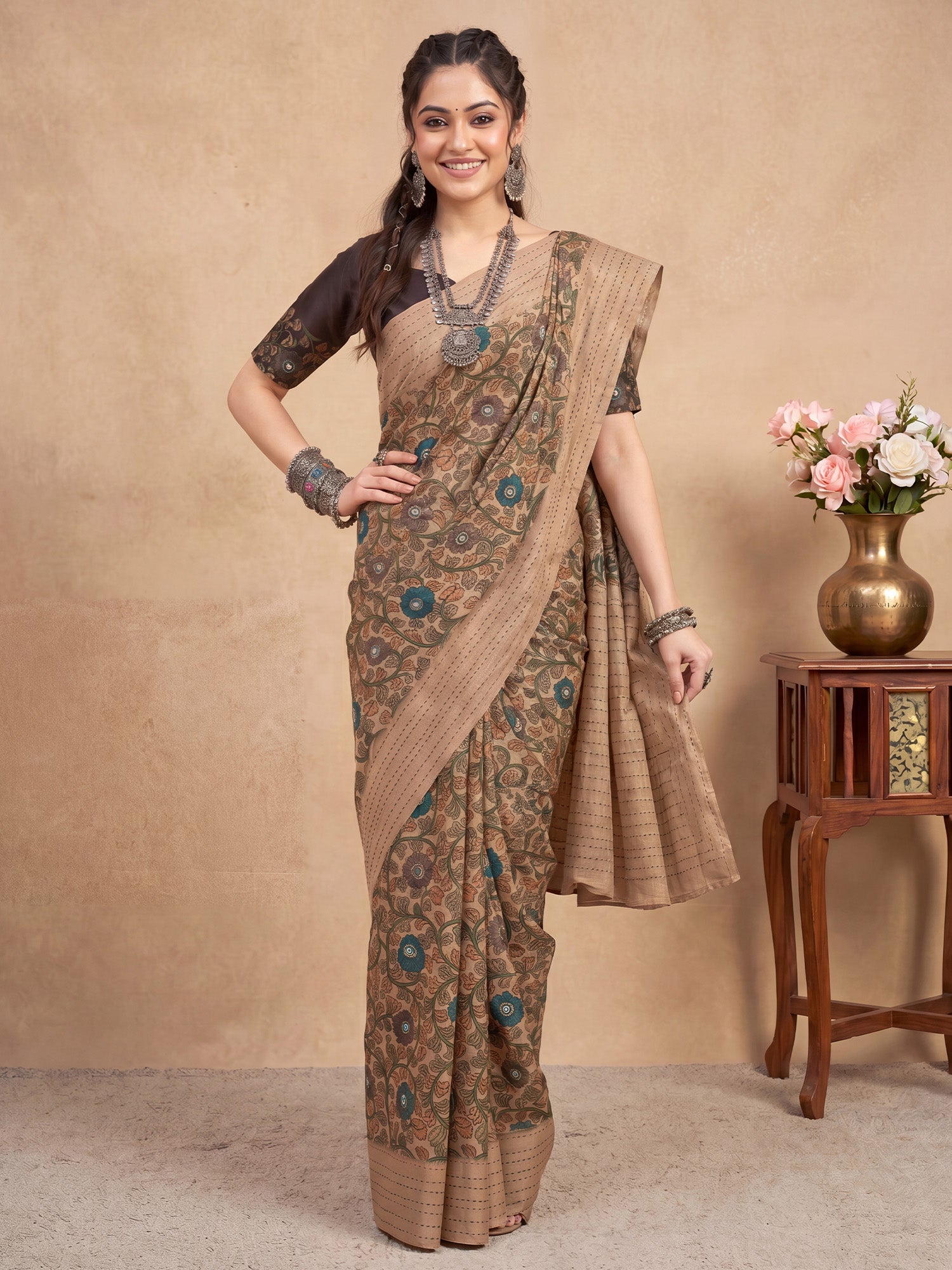 Woman wearing beige silk blend saree with kalamkari narrative motif work and black blouse