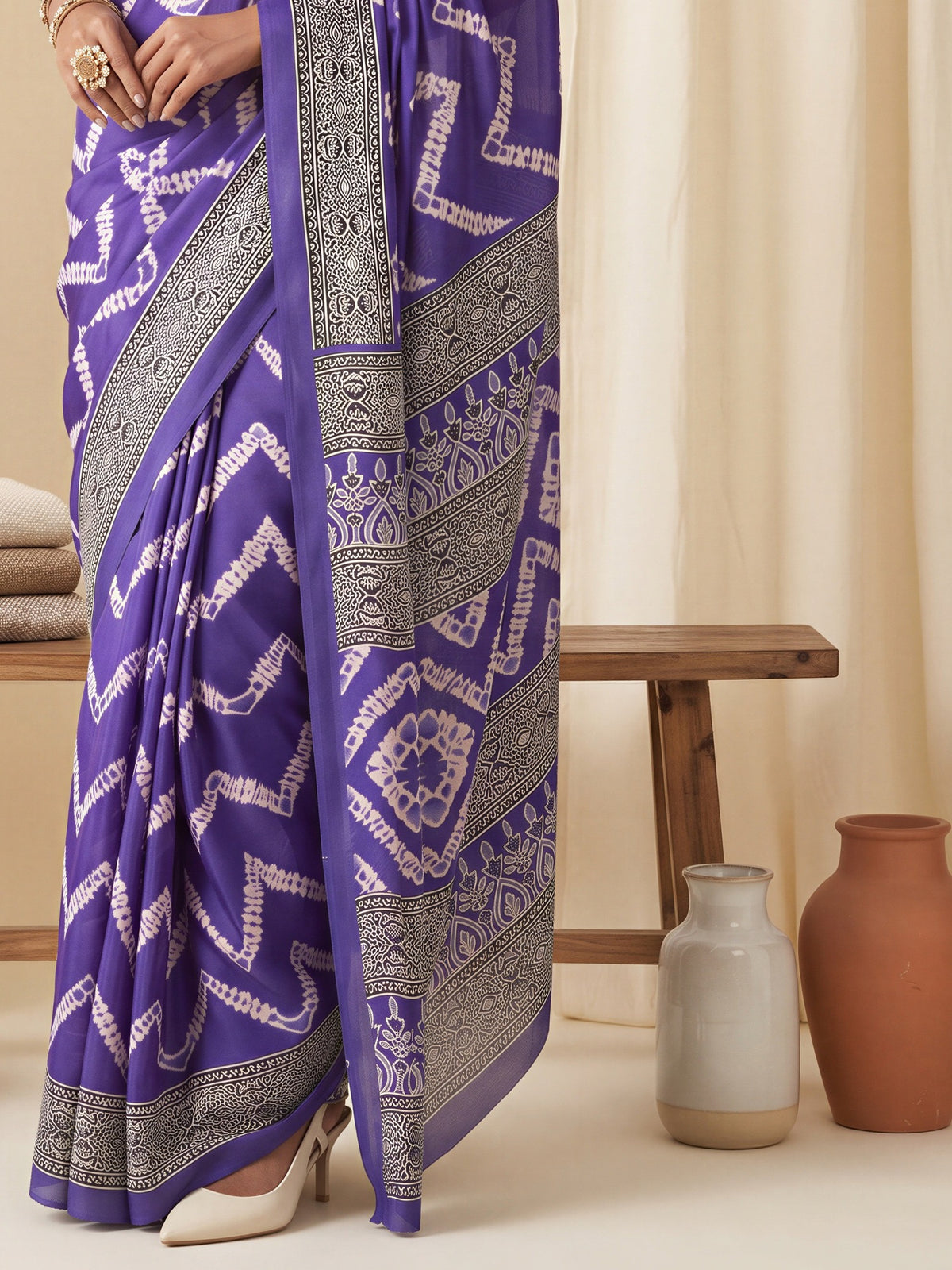 Pallu detail of violet satin saree showing tie-and-dye resist pattern and printed border