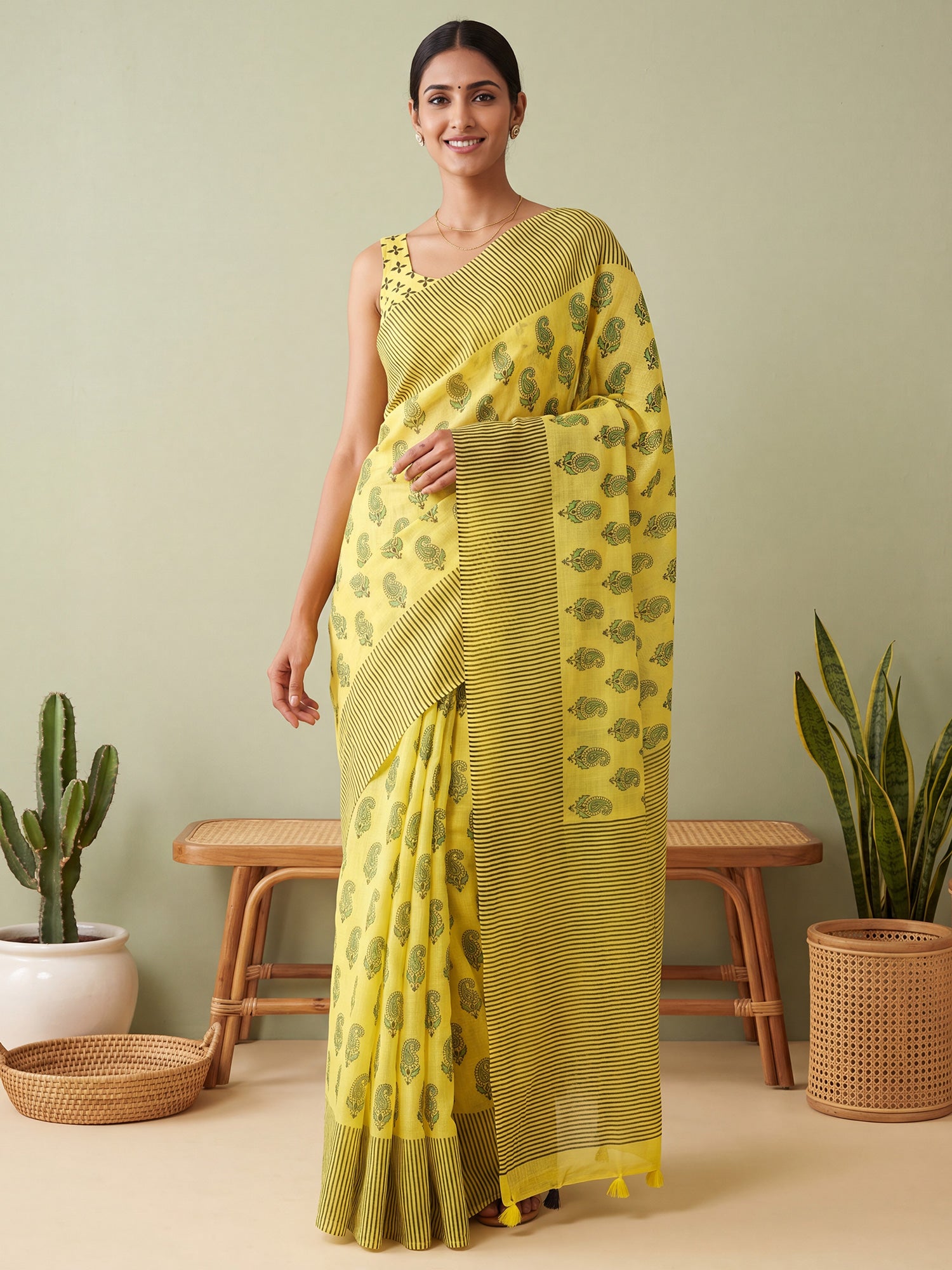 Woman wearing lemon yellow cotton linen saree with traditional indian motif work and lemon yellow blouse