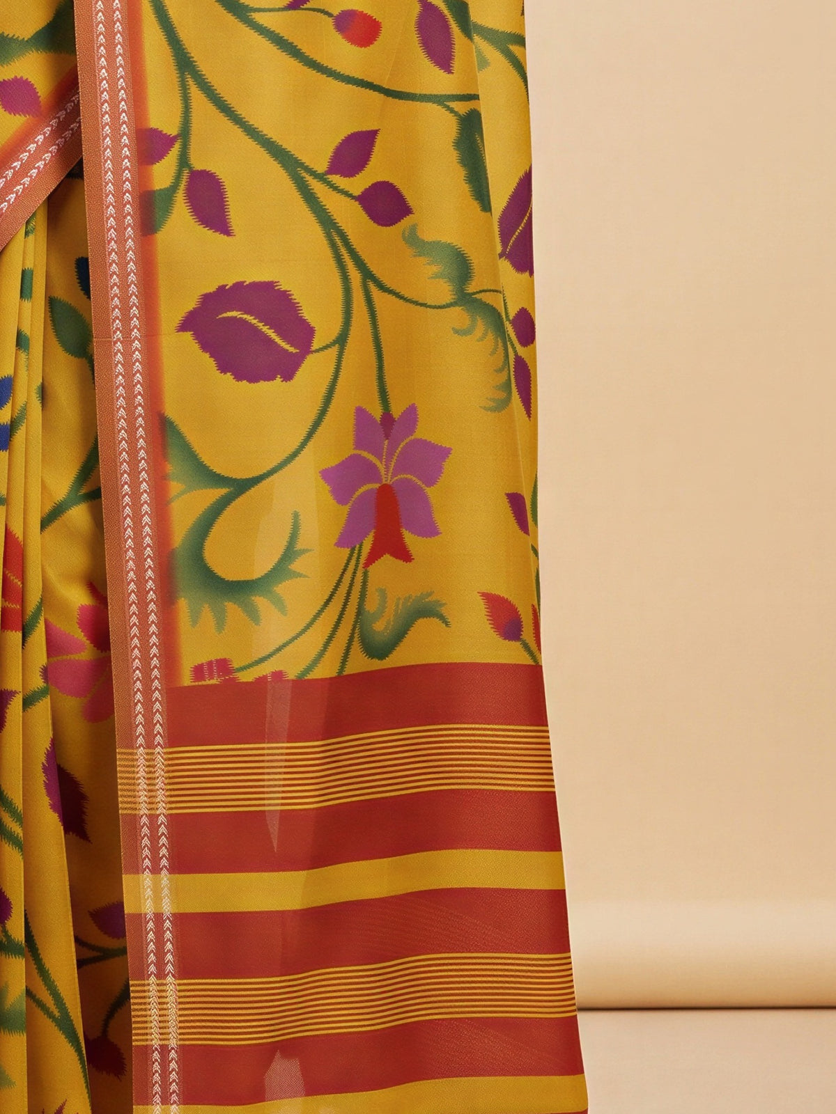 Pallu detail of mustard tussar silk saree showing ikat resist-dyed pattern and printed border