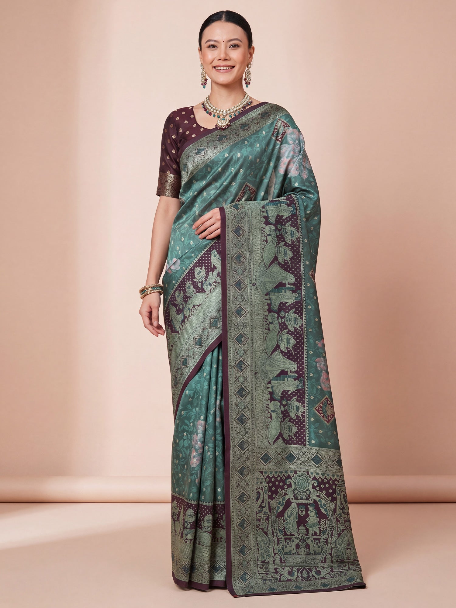 Woman wearing sea green jacquard saree with traditional indian motif work and wine blouse