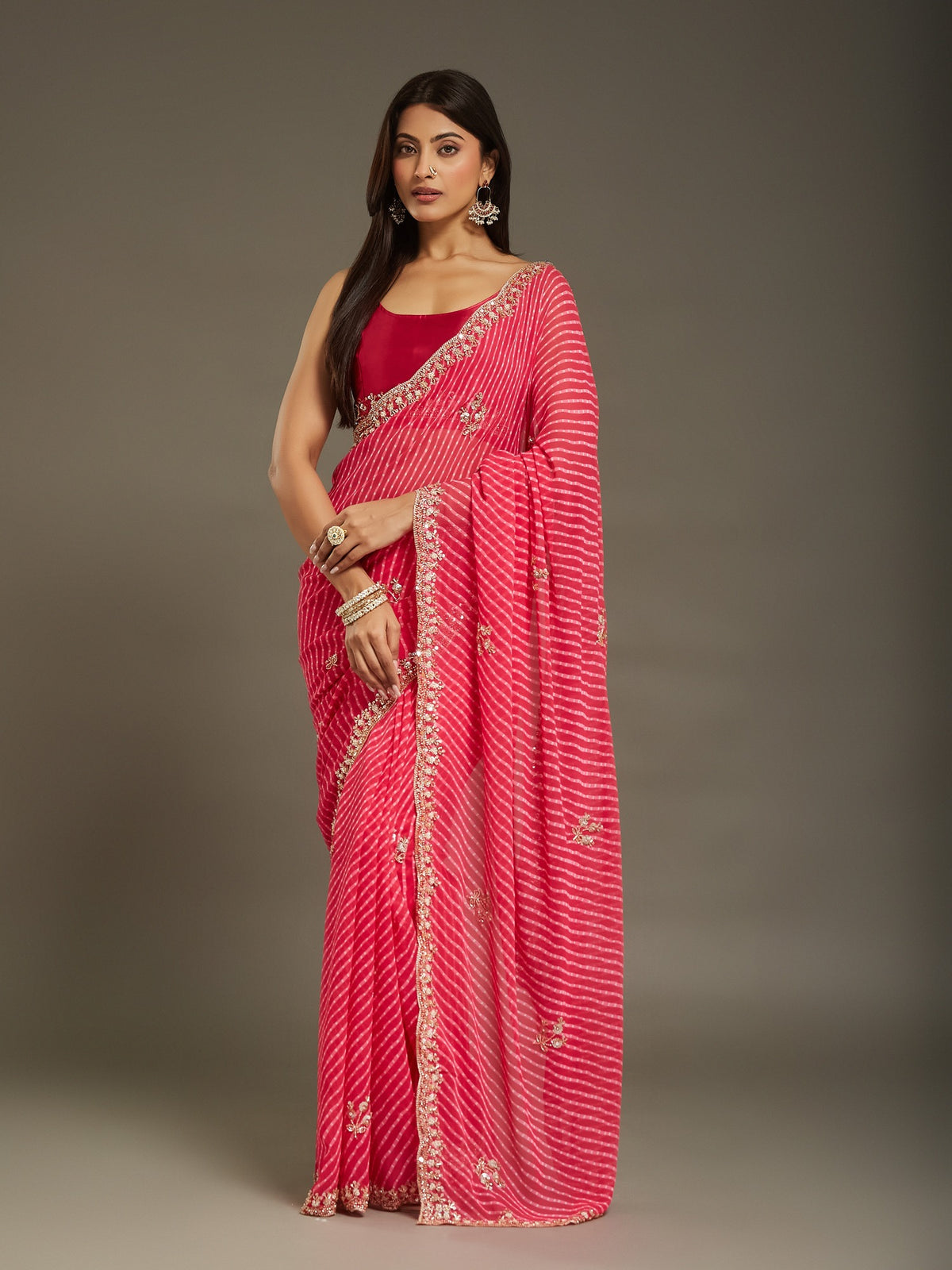 Woman wearing pink georgette saree with leheriya diagonal wave stripes and pink blouse
