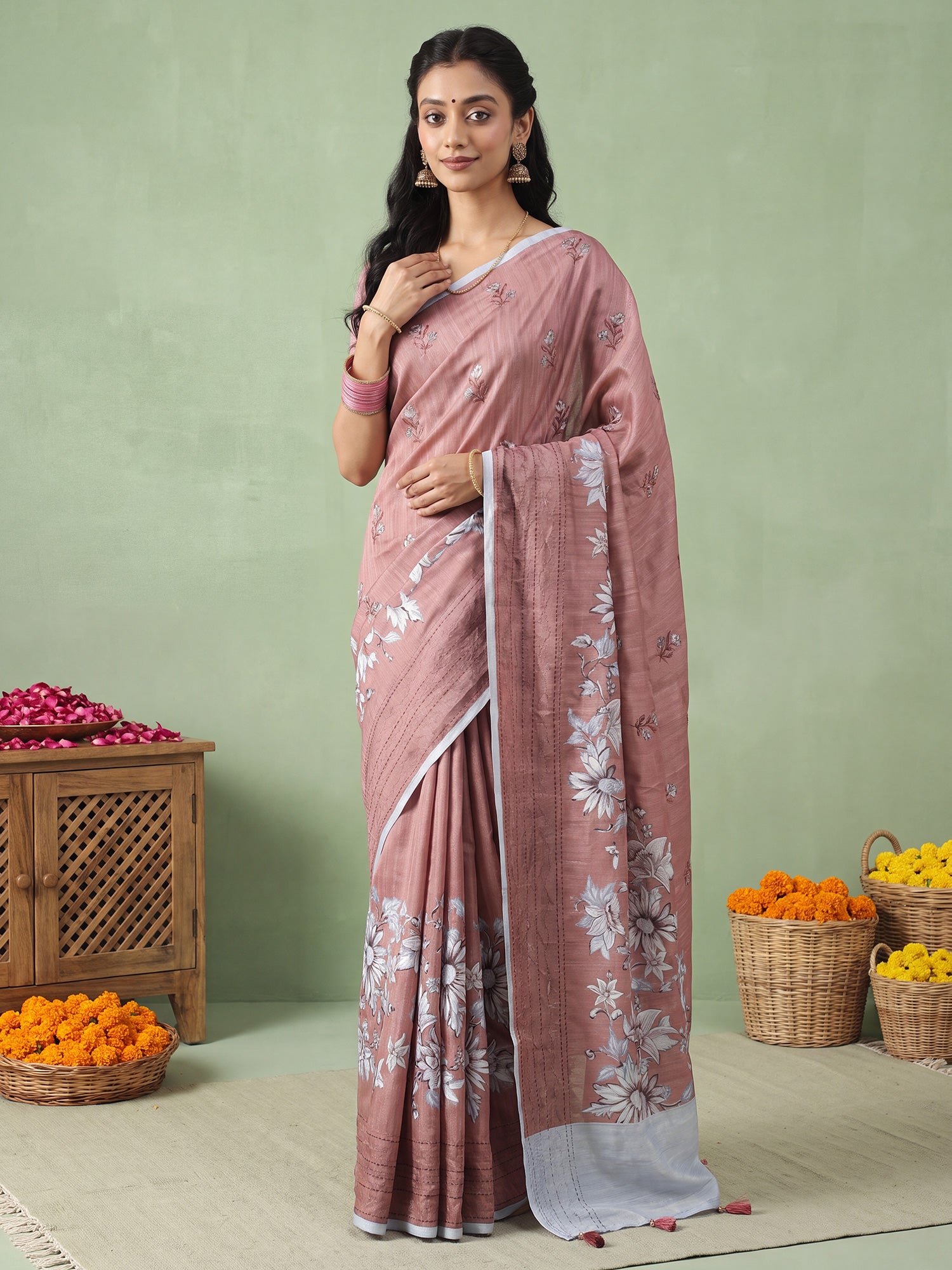 Woman wearing brown silk blend saree with all-over floral design and light blue blouse