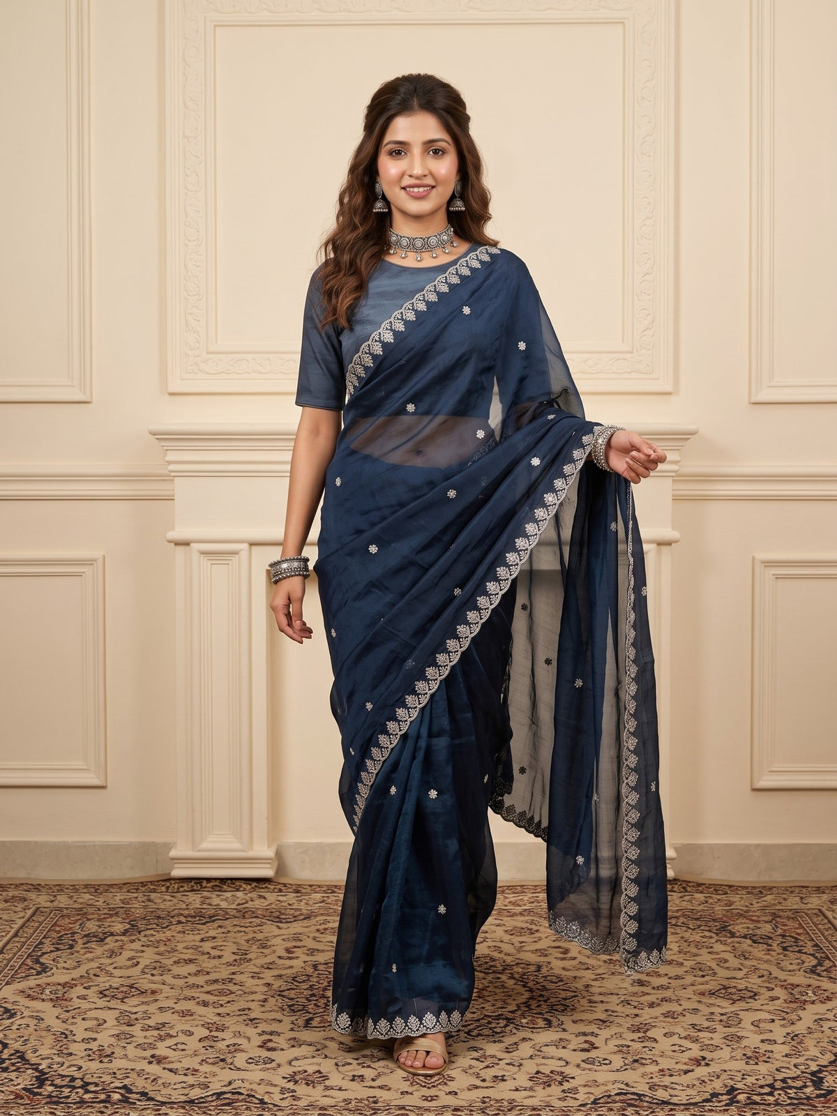 Woman wearing navy blue paper silk saree with embroidered motif work and navy blue blouse