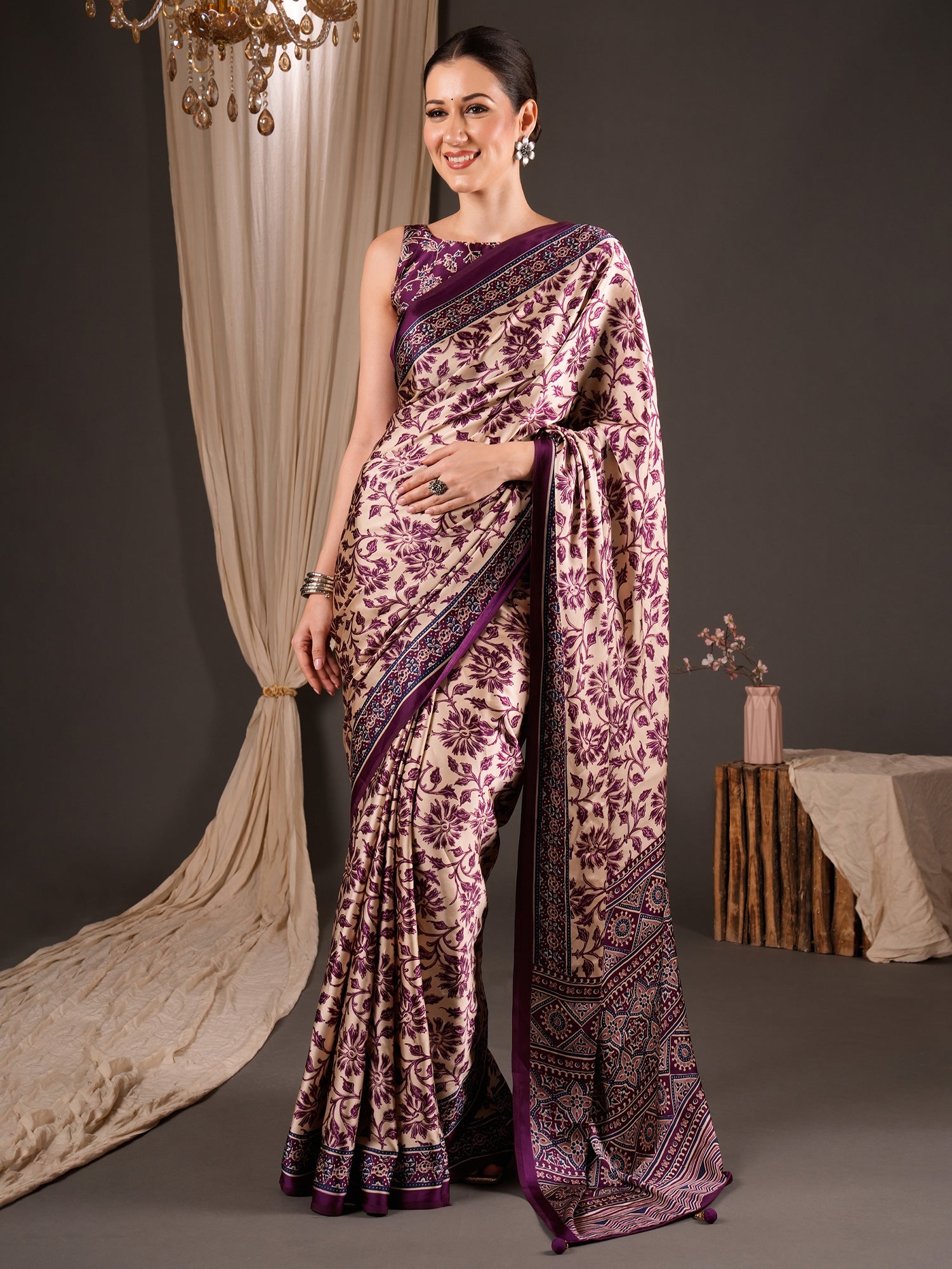 Woman wearing cream satin saree with ajrak block-print motif work and wine blouse
