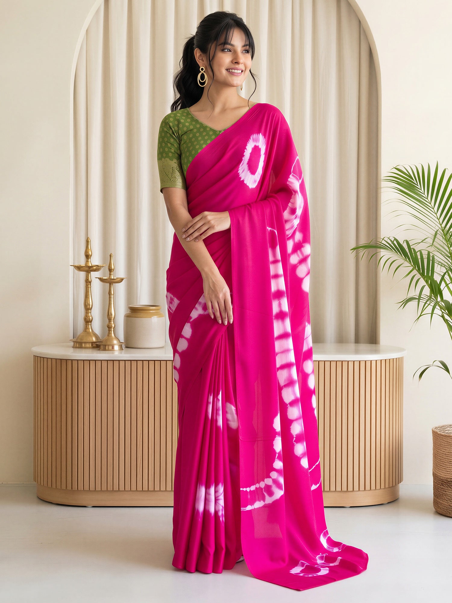 Woman wearing pink satin silk saree with tie-and-dye resist pattern and light green blouse